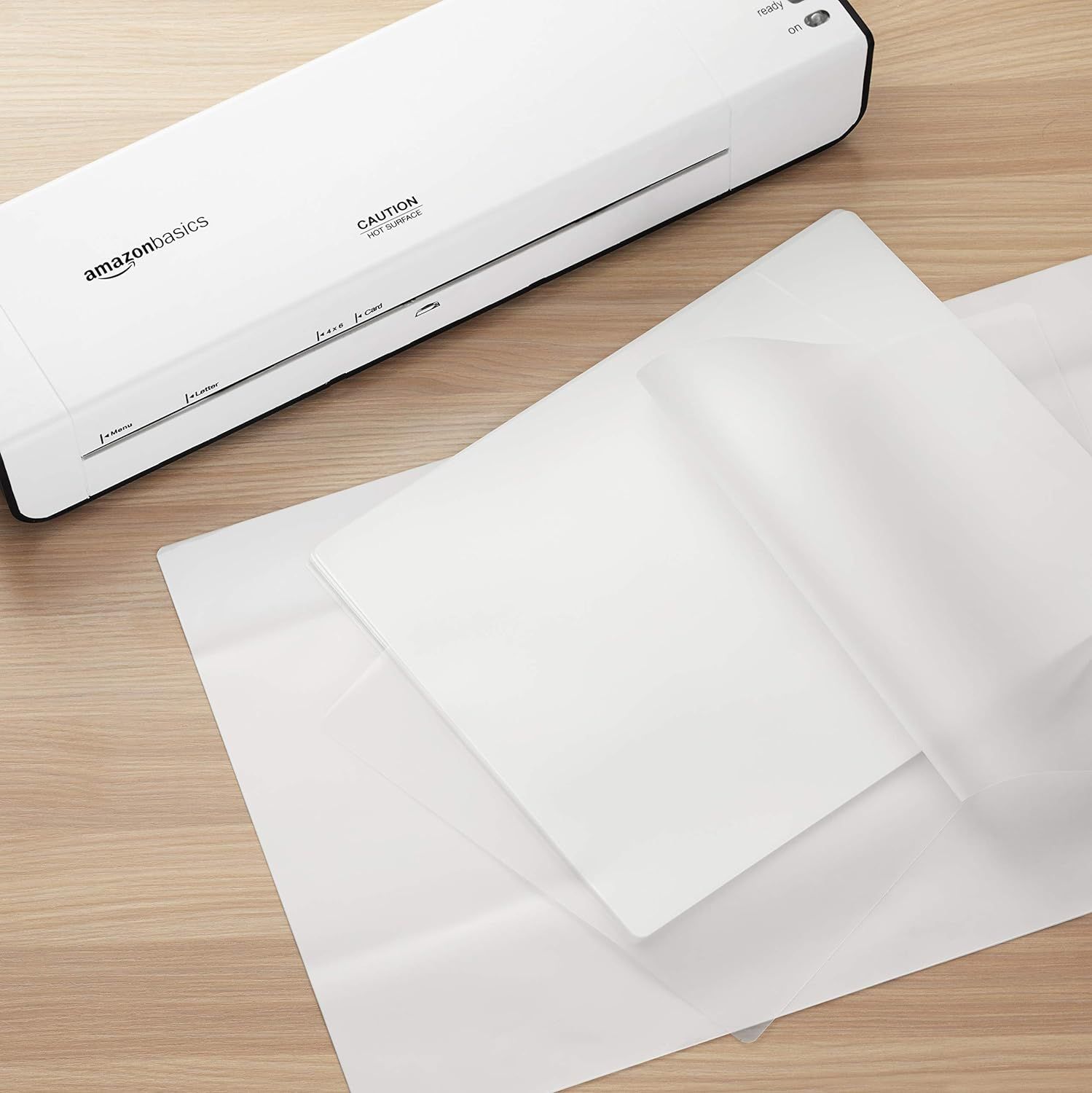 Shows the laminator in a real-world office or home setting with laminated sheets to help shoppers visualize the product in use and understand its practical application.
