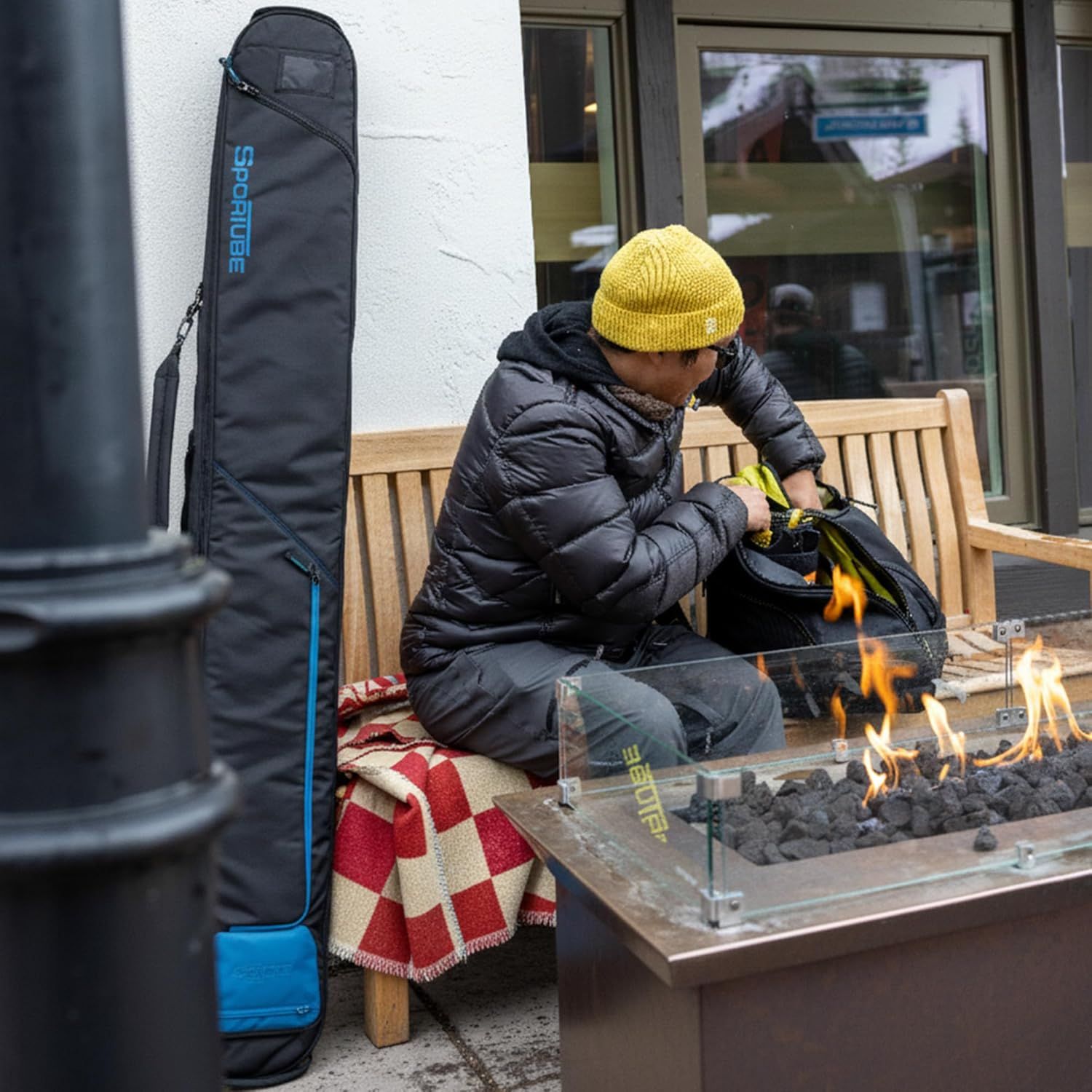 Demonstrates the product in a real-world winter/ski resort environment to help shoppers visualize using it during their outdoor adventures.