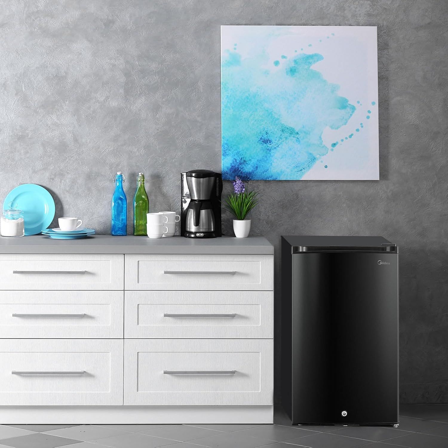 Demonstrates how the compact refrigerator fits naturally into a modern kitchen or living space, helping shoppers visualize the product in their own home environment.