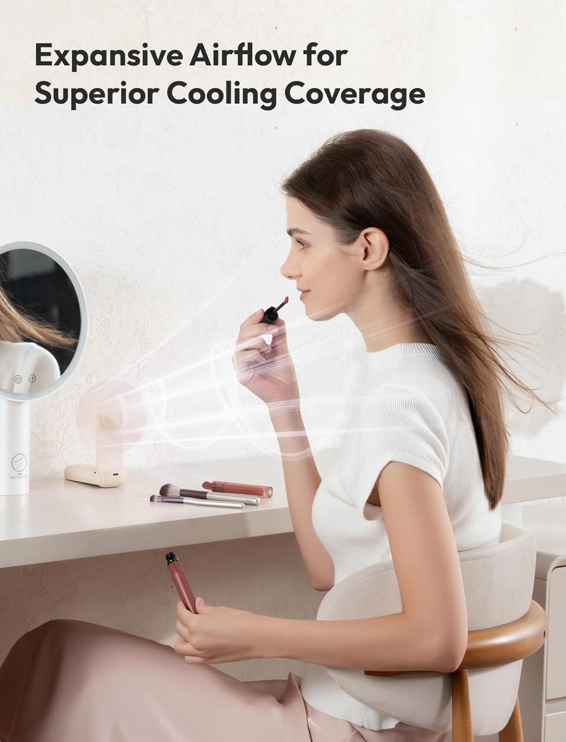 Demonstrates the fan's powerful airflow capability by showing how it effectively cools the user while applying makeup, emphasizing wide cooling coverage and comfort.