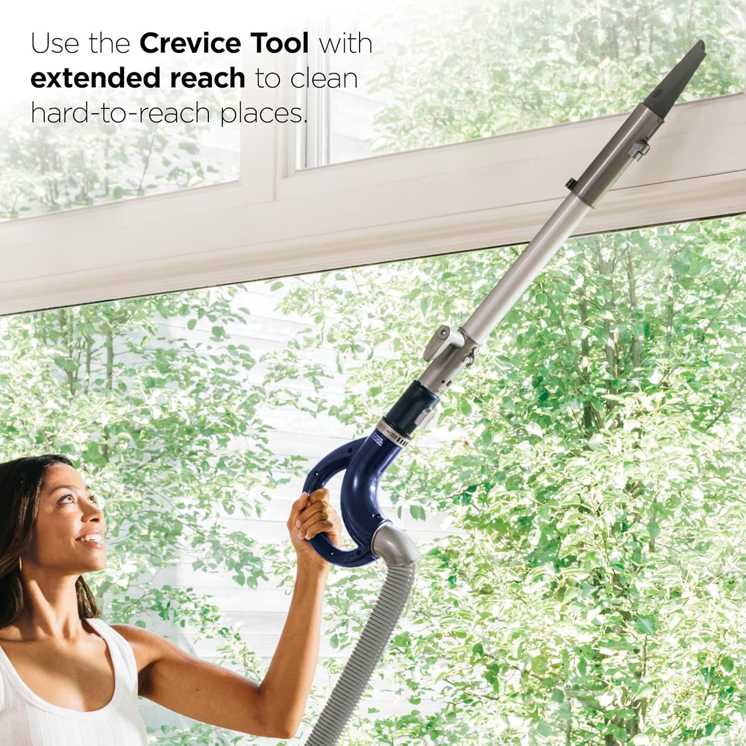 Demonstrates how to use the crevice tool attachment with extended reach to clean hard-to-reach places like ceiling corners and high surfaces. Highlights the extended reach capability of the crevice…