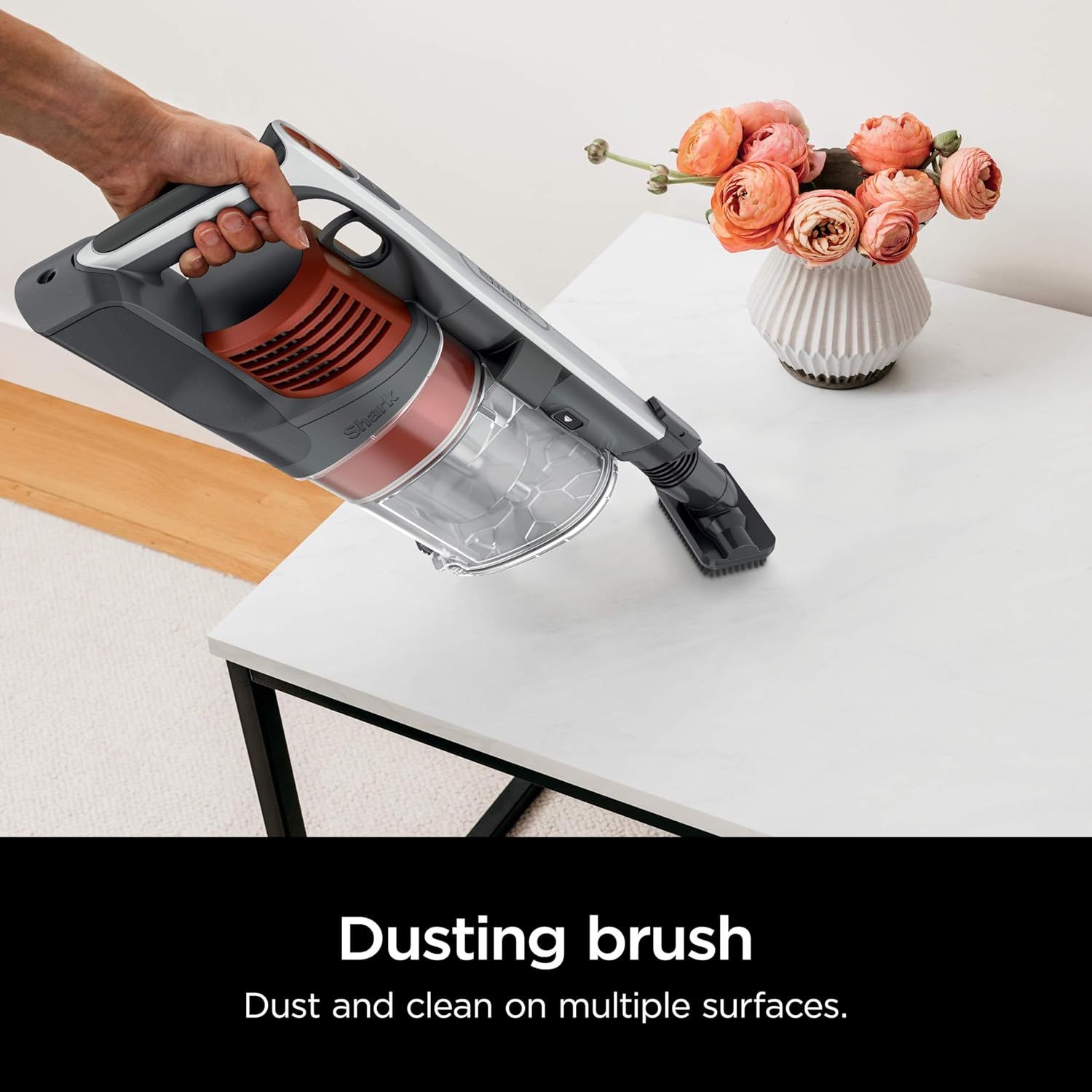 Demonstrates the dusting brush attachment in use to show shoppers that the vacuum can effectively clean multiple surfaces including furniture and delicate items.