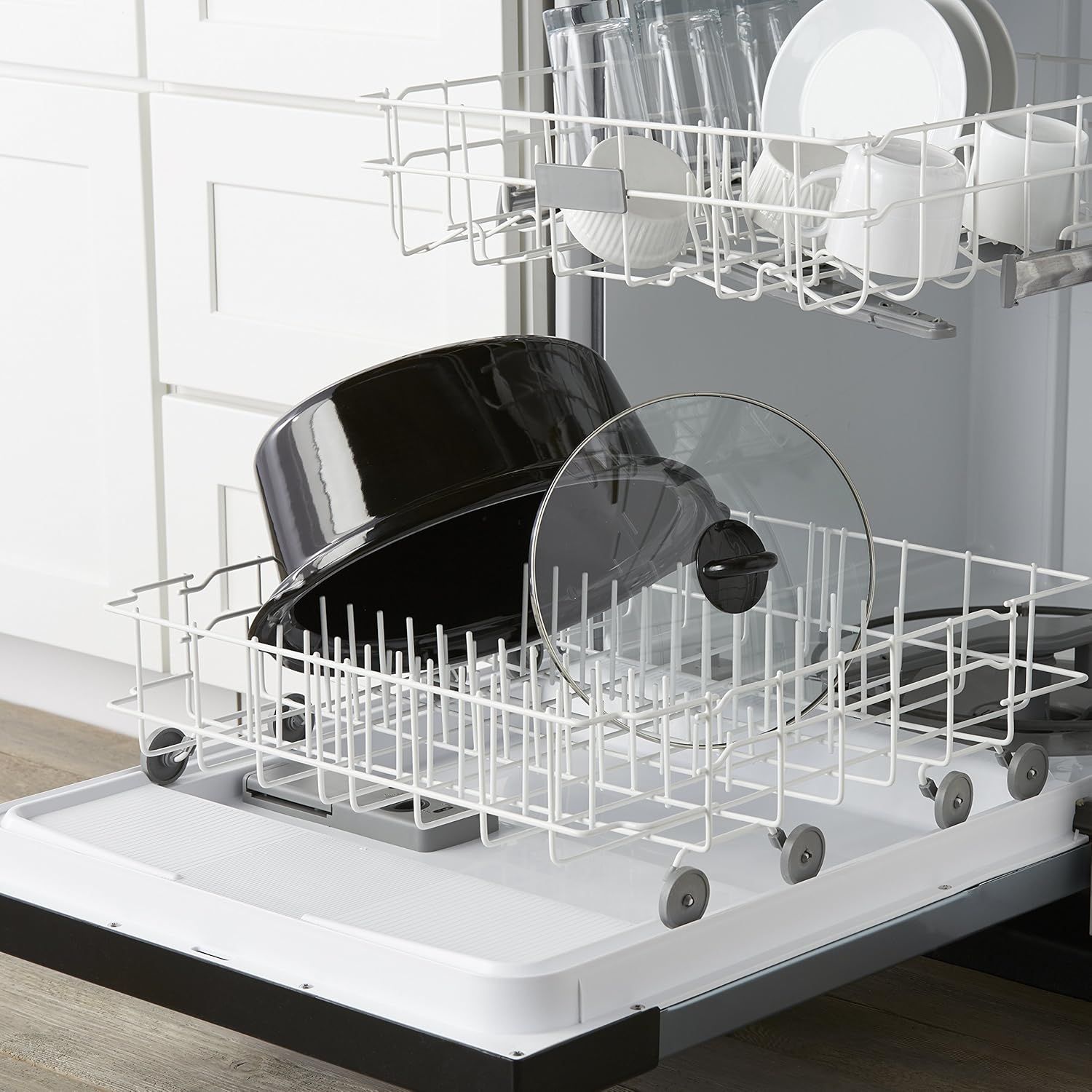 Demonstrates the product in a real-world kitchen context, showing pots and pans loaded in a dishwasher to communicate ease of cleaning and dishwasher compatibility.