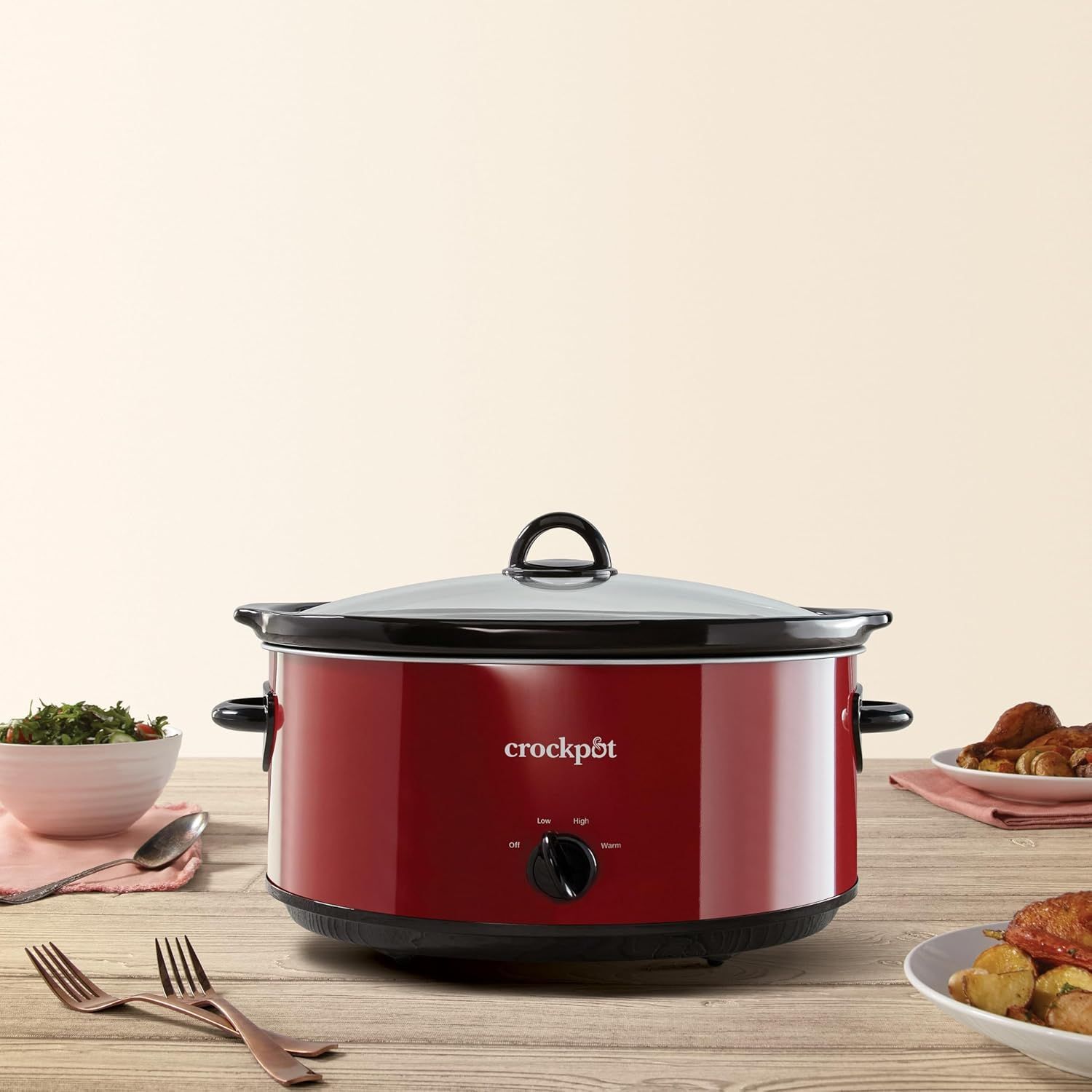 Showcases the Crockpot slow cooker in a real-world dining setting to help shoppers visualize the product in their own home and understand its role in meal preparation.