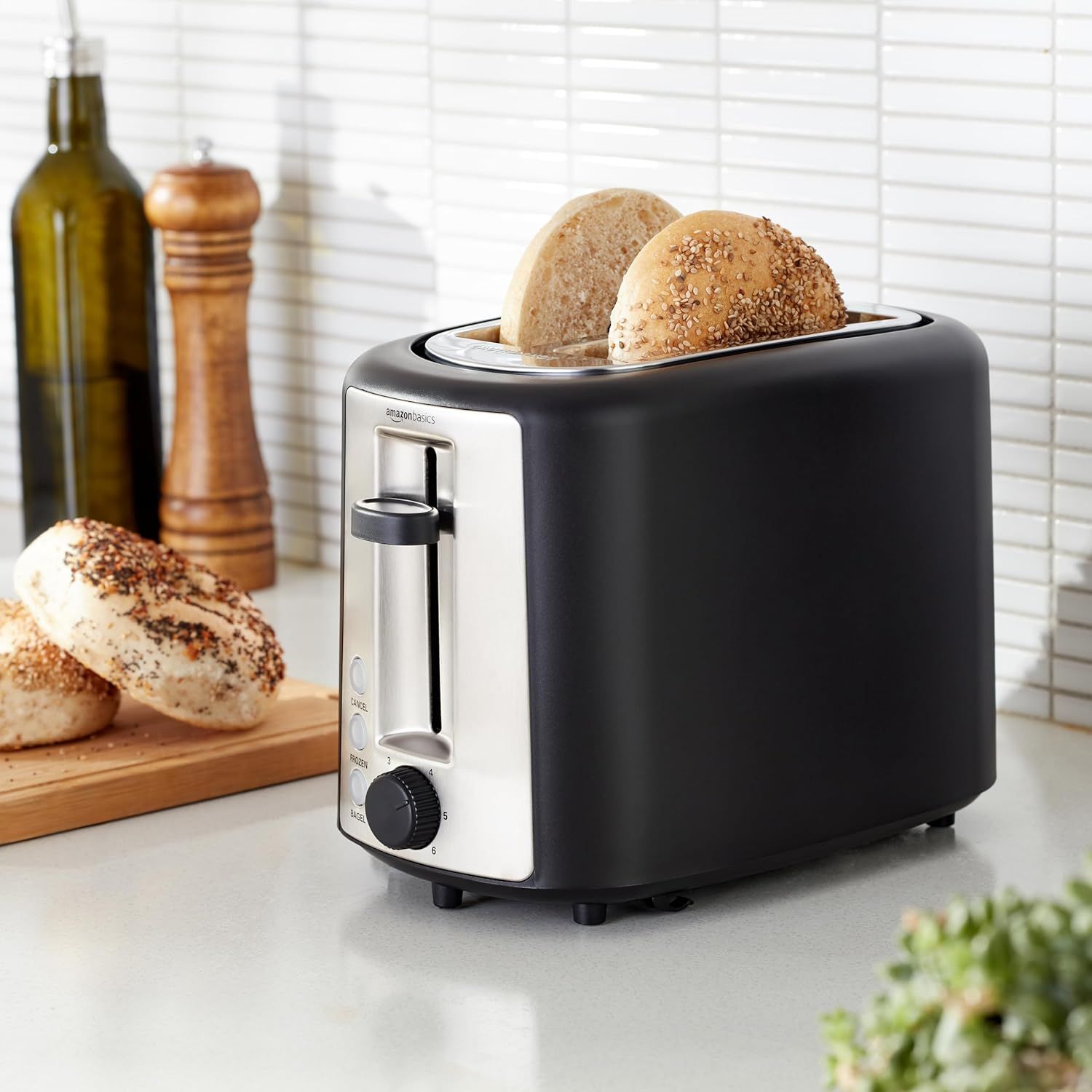 Shows the toaster in a real-world kitchen setting with bagels being toasted, helping shoppers visualize the product in their own home and understand its everyday use.