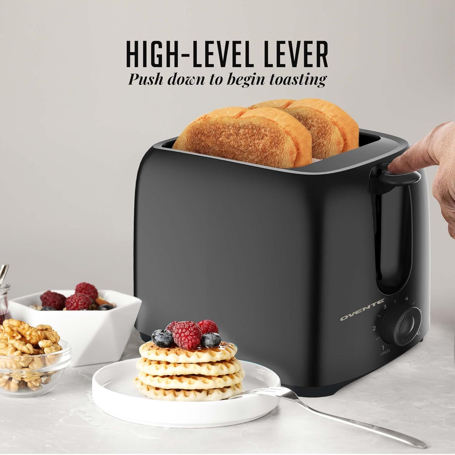 Highlights the toaster's high-level lever feature that allows users to easily push down to begin toasting, emphasizing ease of use and convenience.