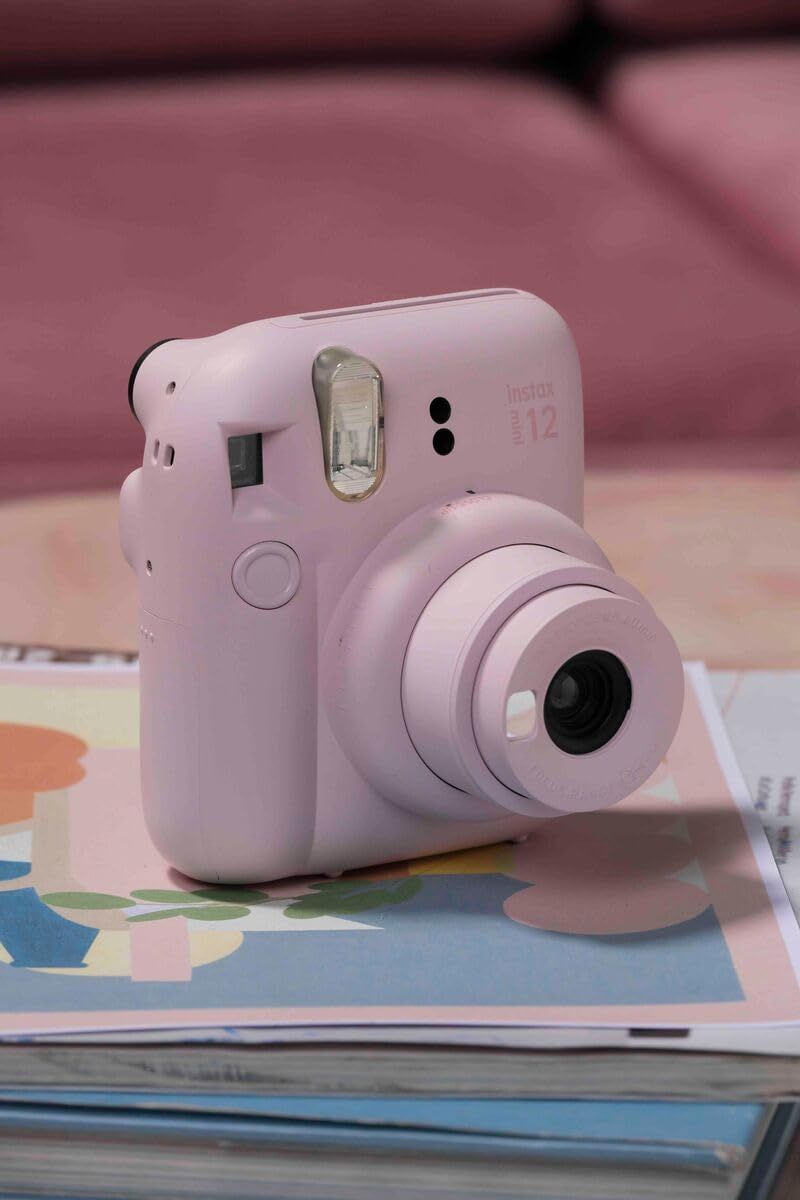 Shows the Instax camera in a lifestyle setting with printed photos to help shoppers visualize the product in everyday use and create an emotional connection.
