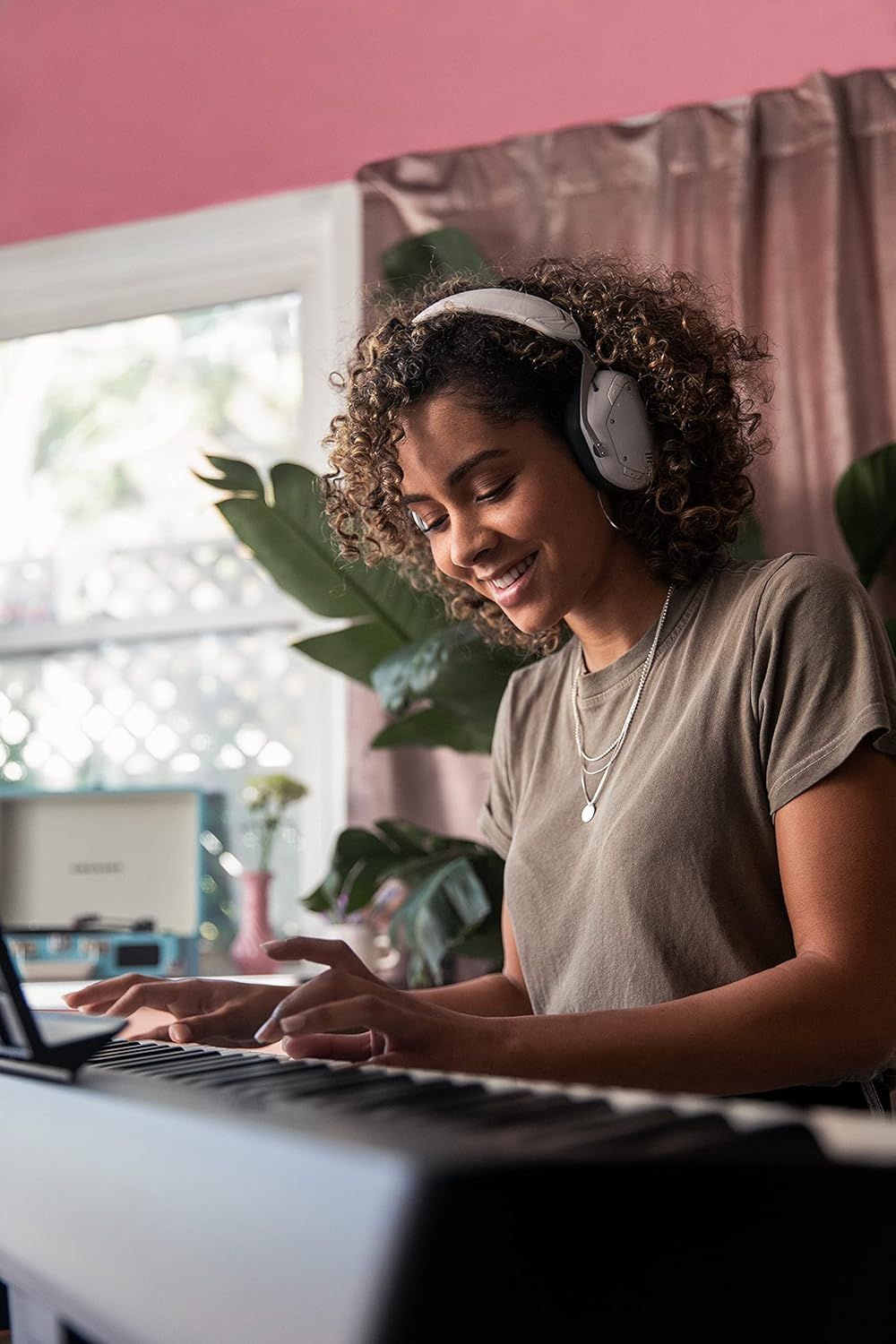 Shows the product (headphones) being used in a real-world home setting to help shoppers visualize how they would use it in their daily life for work or leisure.