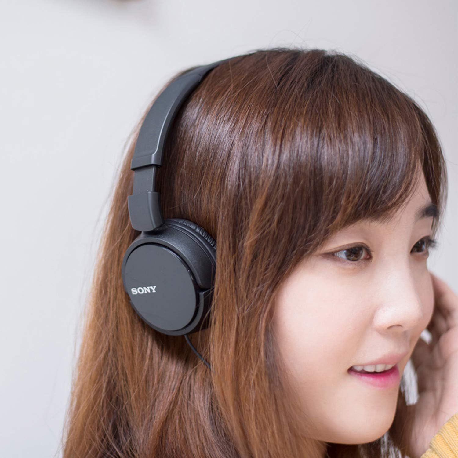 Demonstrates the product being worn and used in a real-world setting to help shoppers visualize themselves using the headphones.