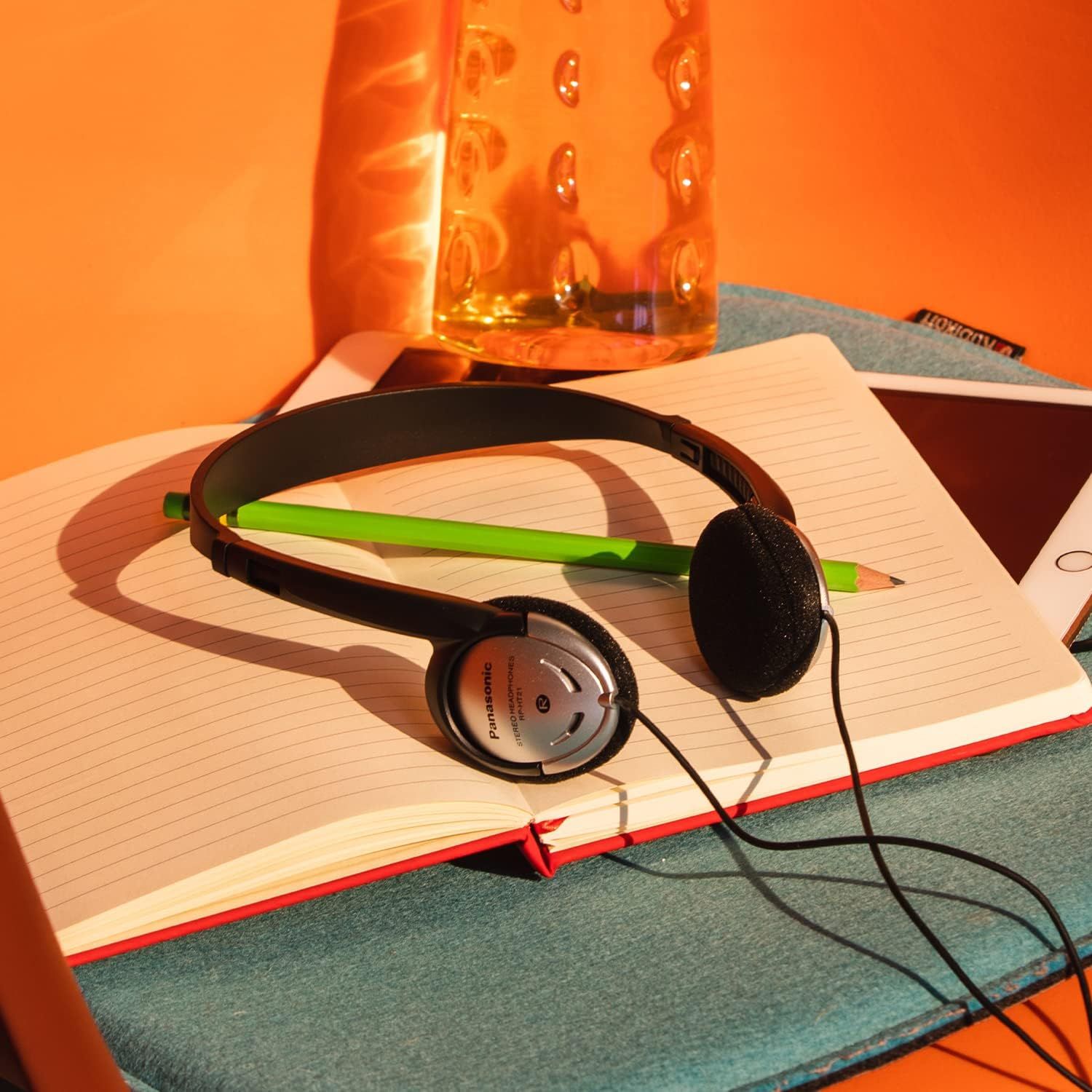 Showcases the product in a real-world desk setting to help shoppers visualize how the headphones fit into their daily study or work routine.