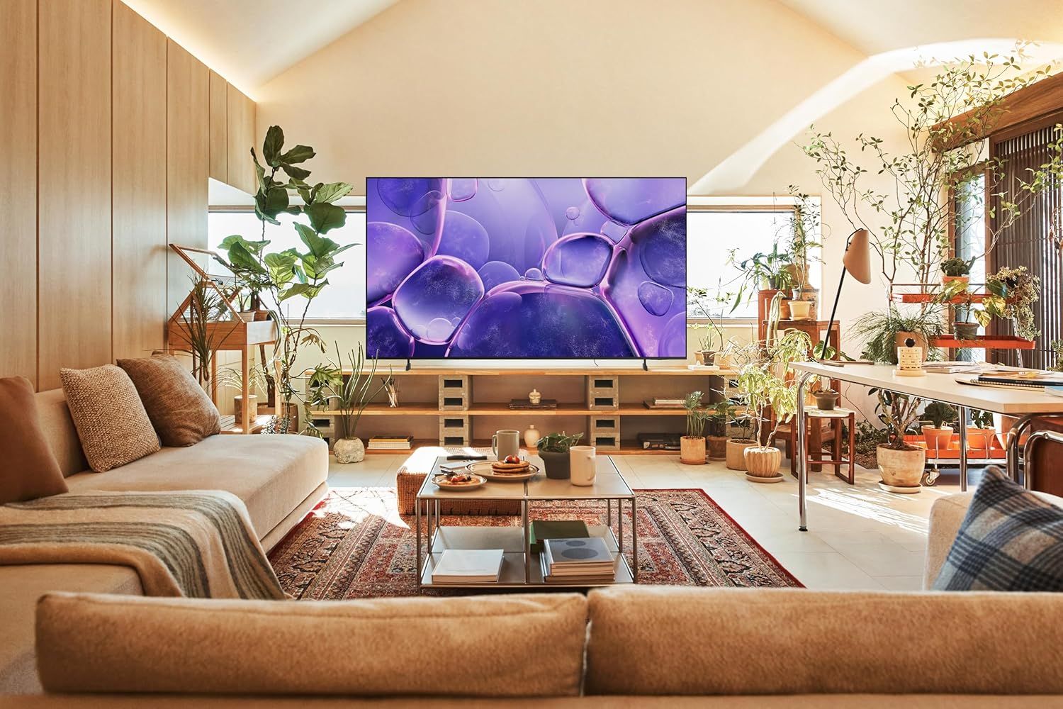 Demonstrates the product (television) in a real-world living room environment to help shoppers visualize how it would look and fit in their own home.