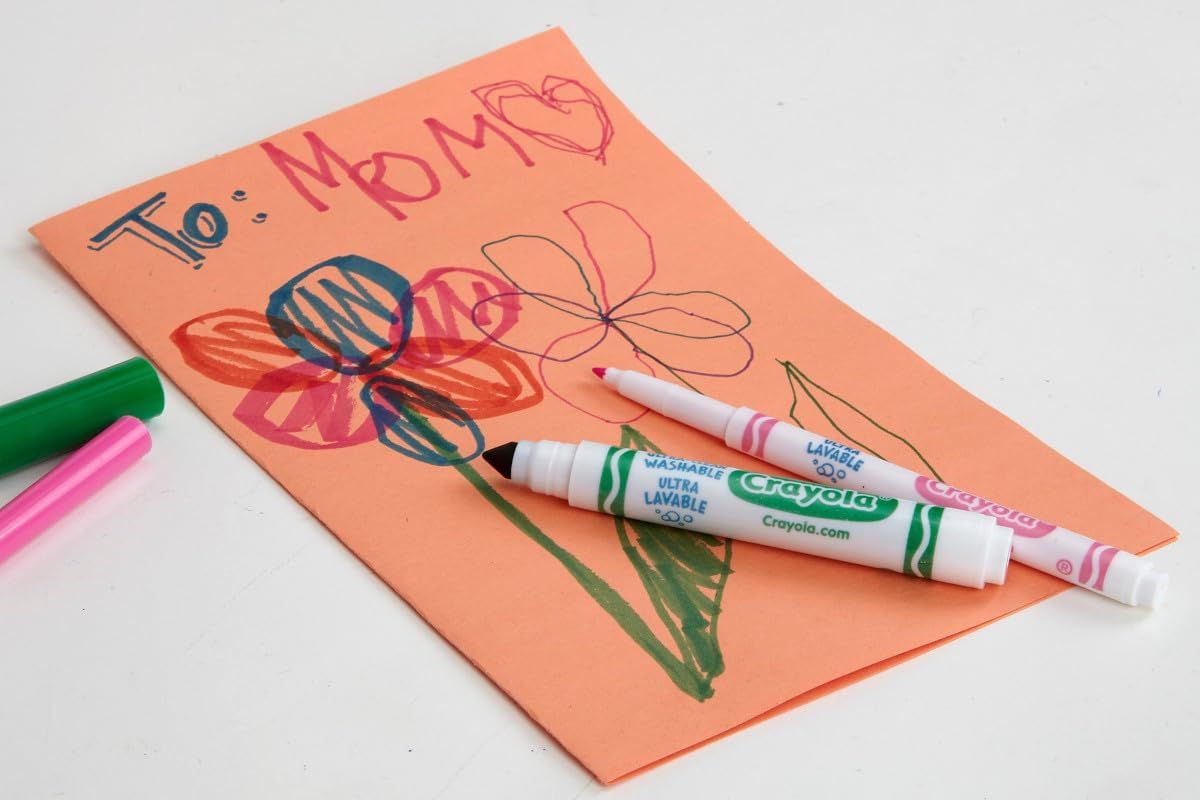 Shows the product being used in a real-world context (creating a Mother's Day card) to help shoppers visualize how the markers can be used for creative projects and gift-making.