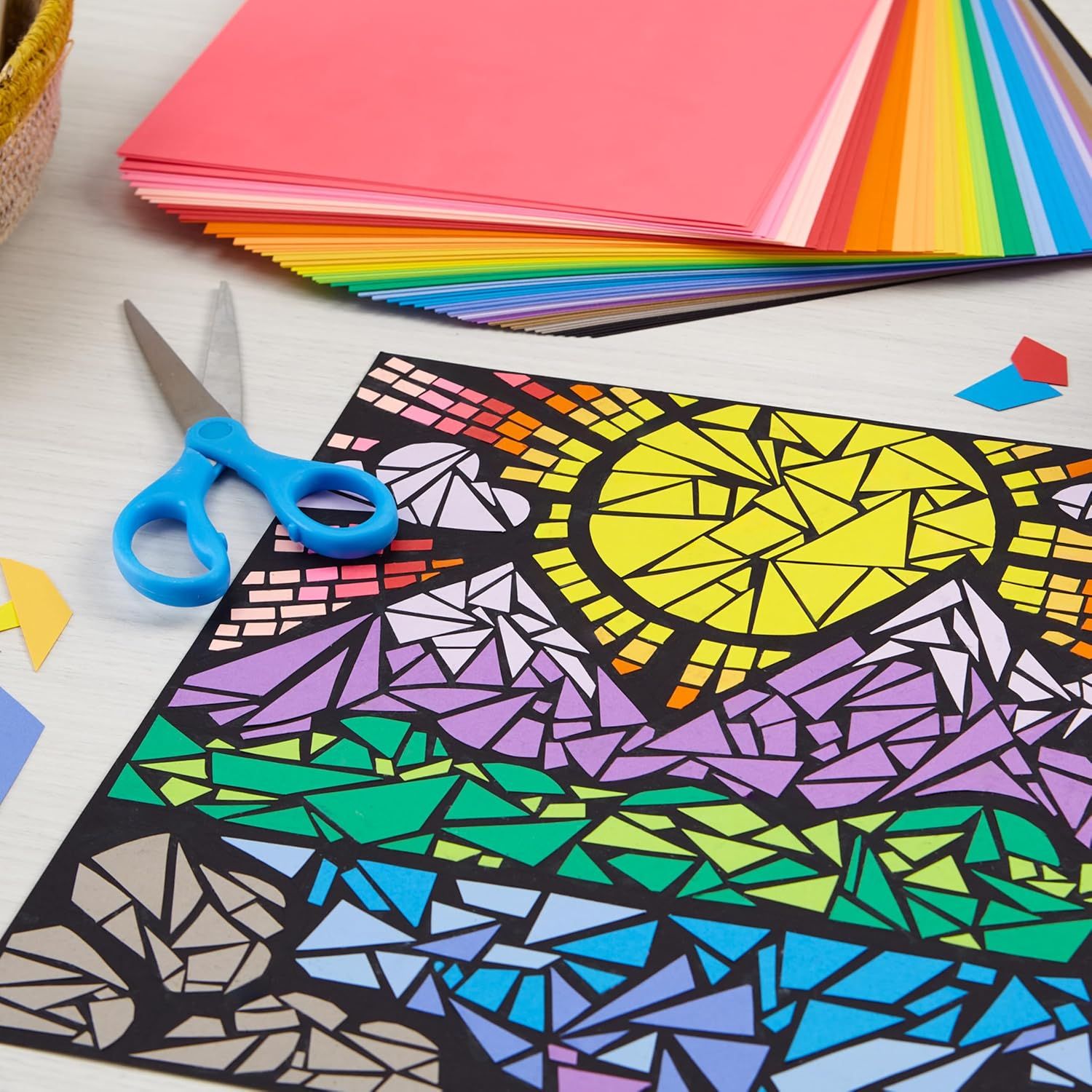 Shows shoppers everything included in the craft kit—colorful paper sheets, scissors, and a geometric art template—to demonstrate the complete value and creative possibilities of the purchase.