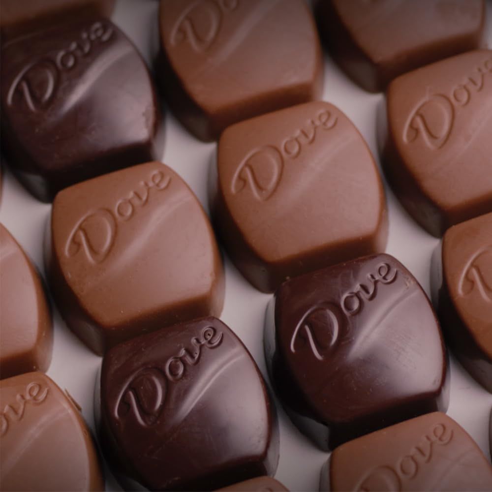 Showcases the Dove brand identity through embossed logo on chocolate pieces in multiple varieties (milk and dark chocolate), reinforcing brand recognition and product range.