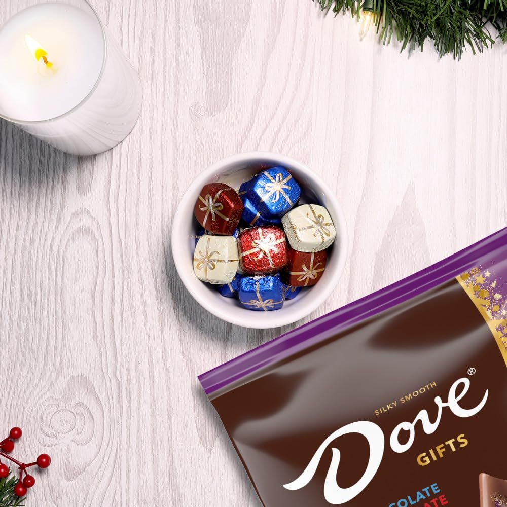 Positions the product as a perfect gift for the holiday season, using festive styling with candles, evergreen branches, and wrapped chocolates to evoke warmth and celebration.