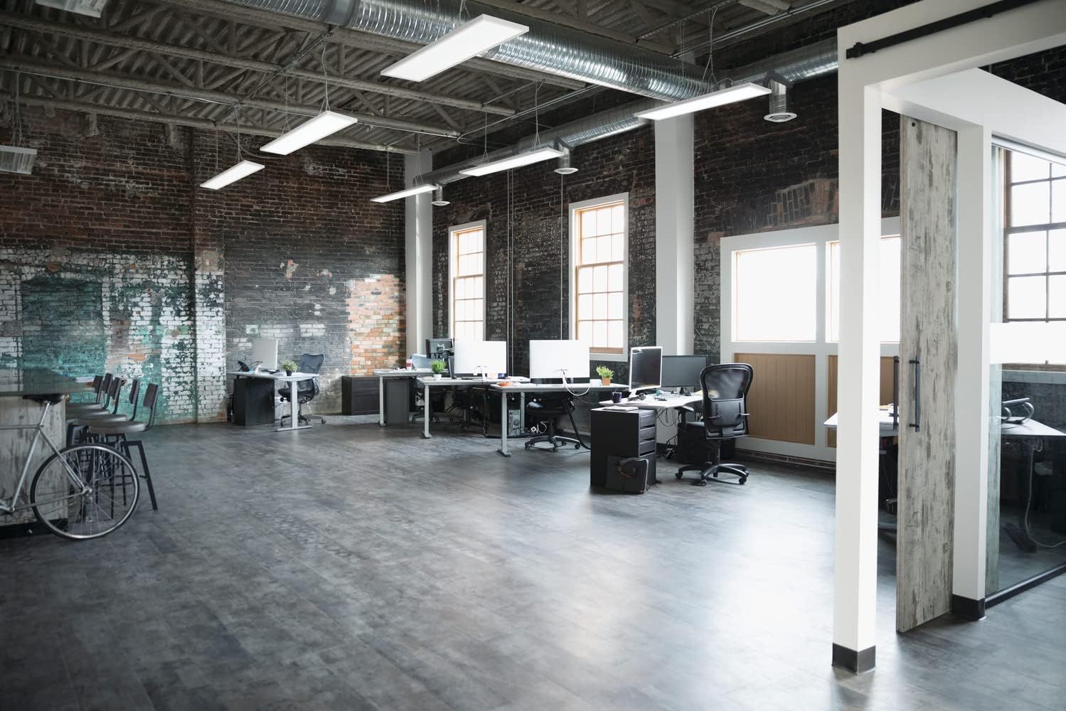 Showcases the product in a real-world office setting with exposed brick and industrial design to help shoppers visualize how it fits into modern workspace environments.