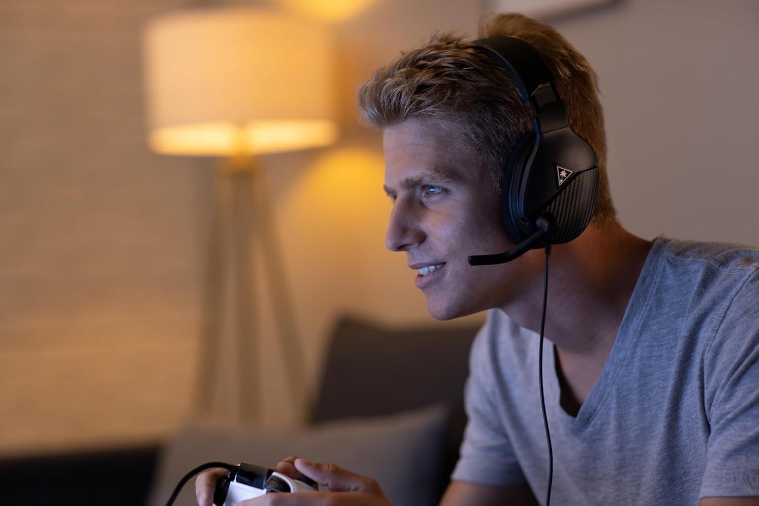 Shows the product being used in a real-world gaming environment to help shoppers visualize themselves using the headset at home.