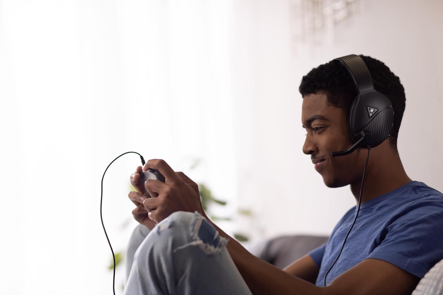 Demonstrates the product in a real-world gaming context to help shoppers visualize themselves using the headset during gameplay.