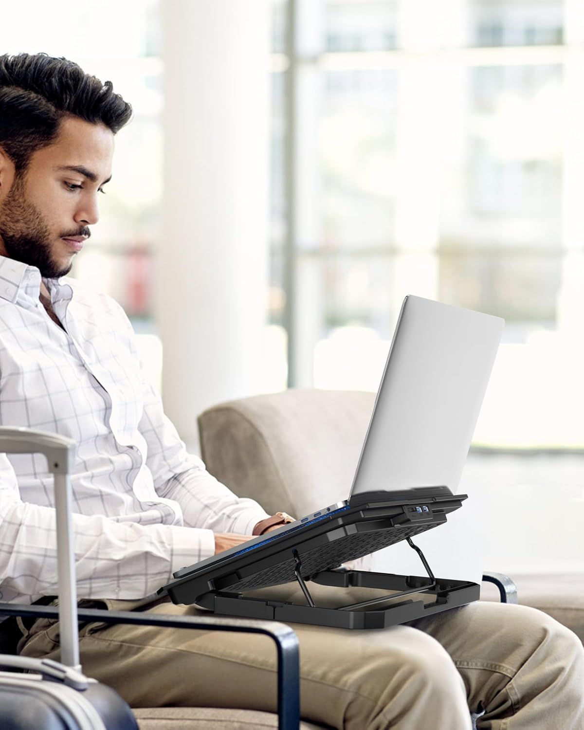Demonstrates the product in a real-world office or home setting, showing how the laptop stand fits naturally into a professional's daily workflow.