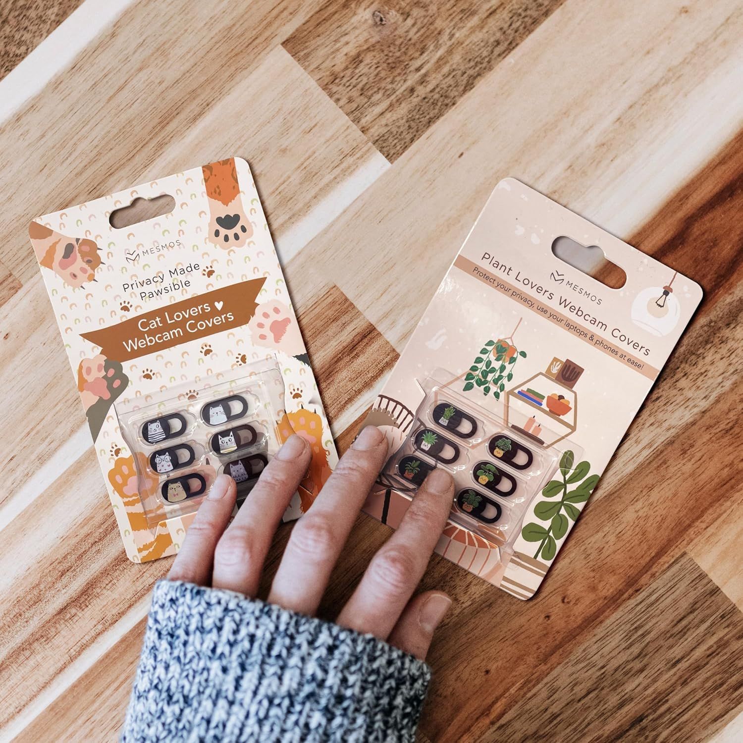 Showcases two different themed webcam cover options from the same brand (Cat Lovers and Plant Lovers) to help shoppers choose which design suits their preferences.