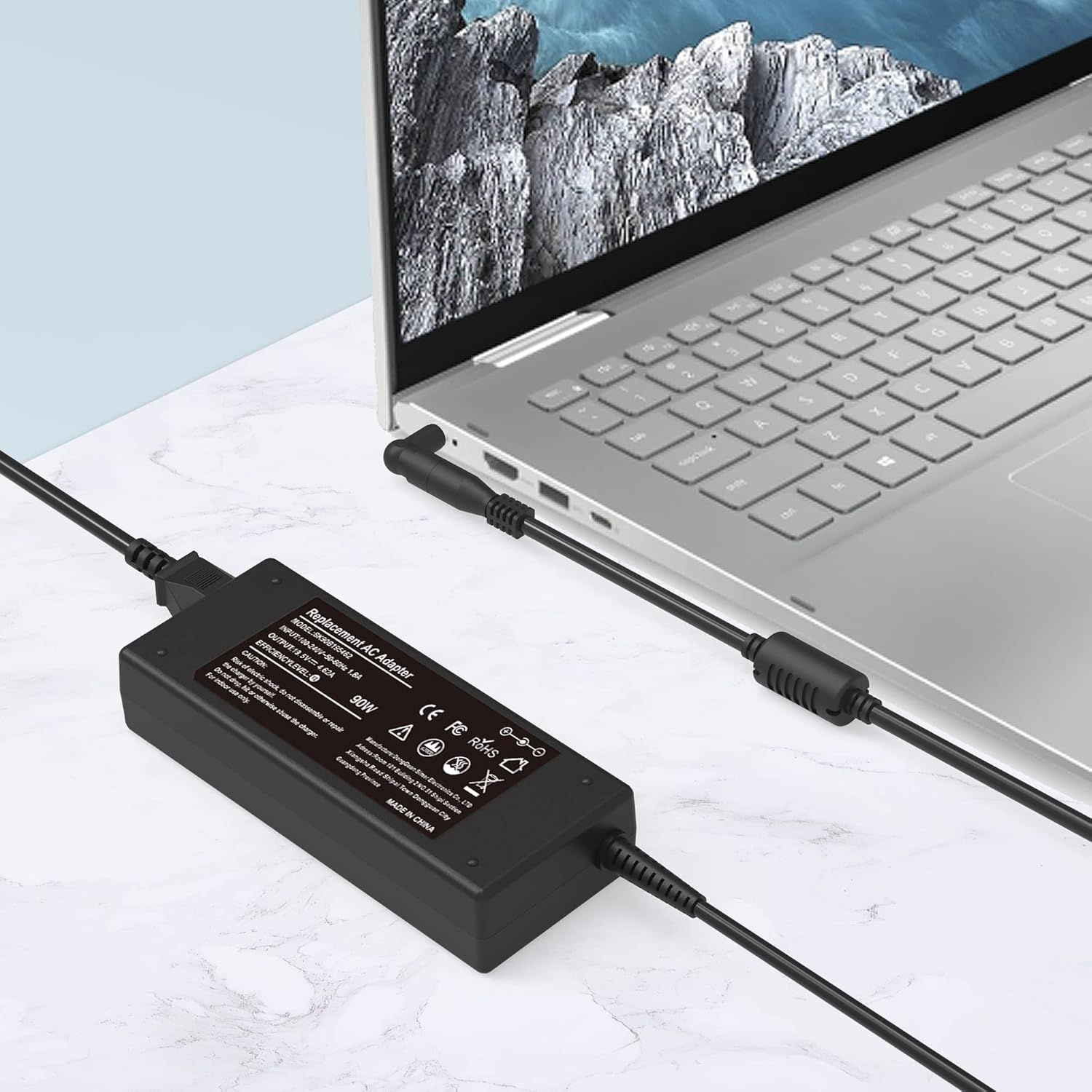 Demonstrates the product in a real-world setting with a laptop to show how the charger/adapter is used in everyday computing scenarios.