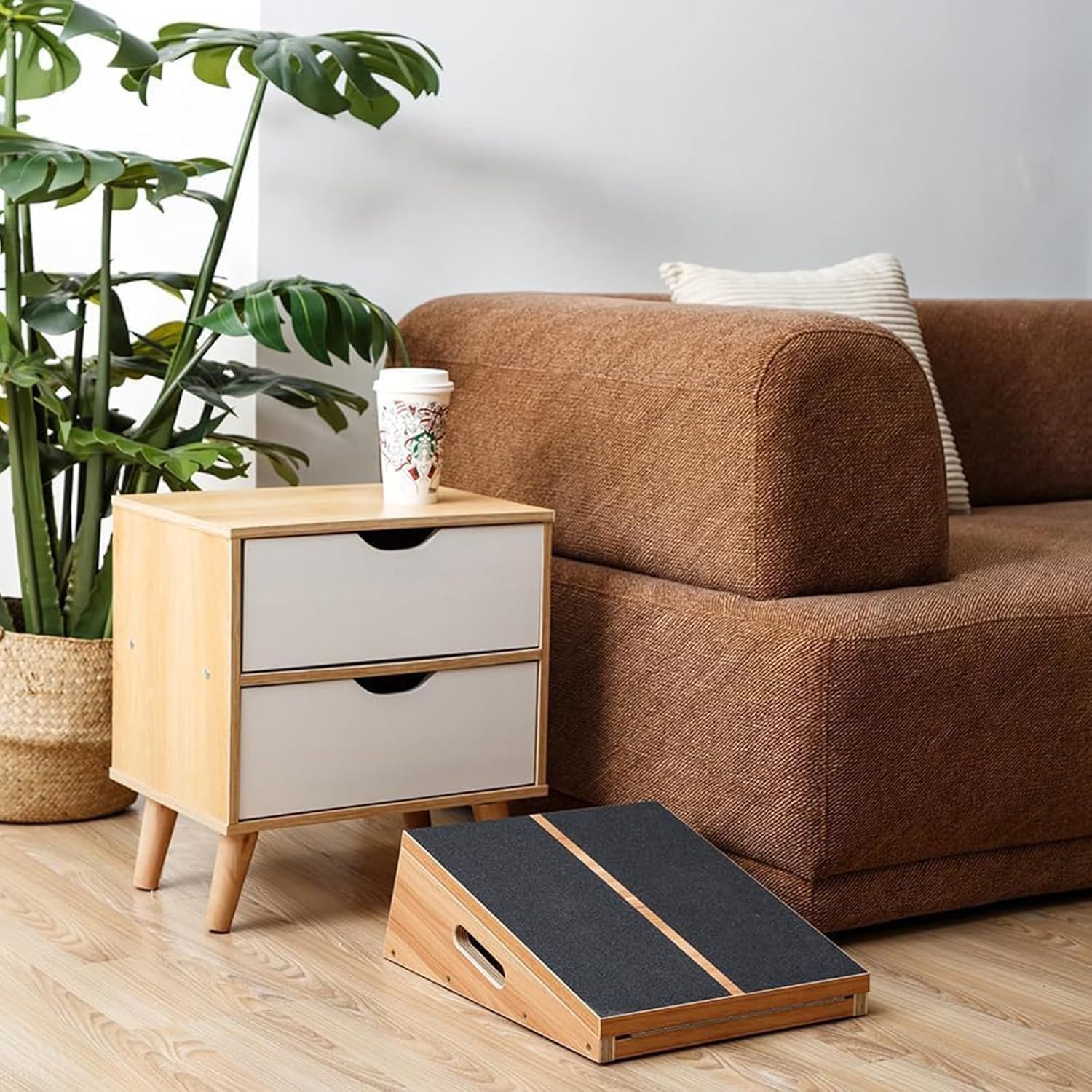 Demonstrates the product (pet ramp) in a real-world living room setting to help shoppers visualize how it fits naturally into their home décor and daily life.