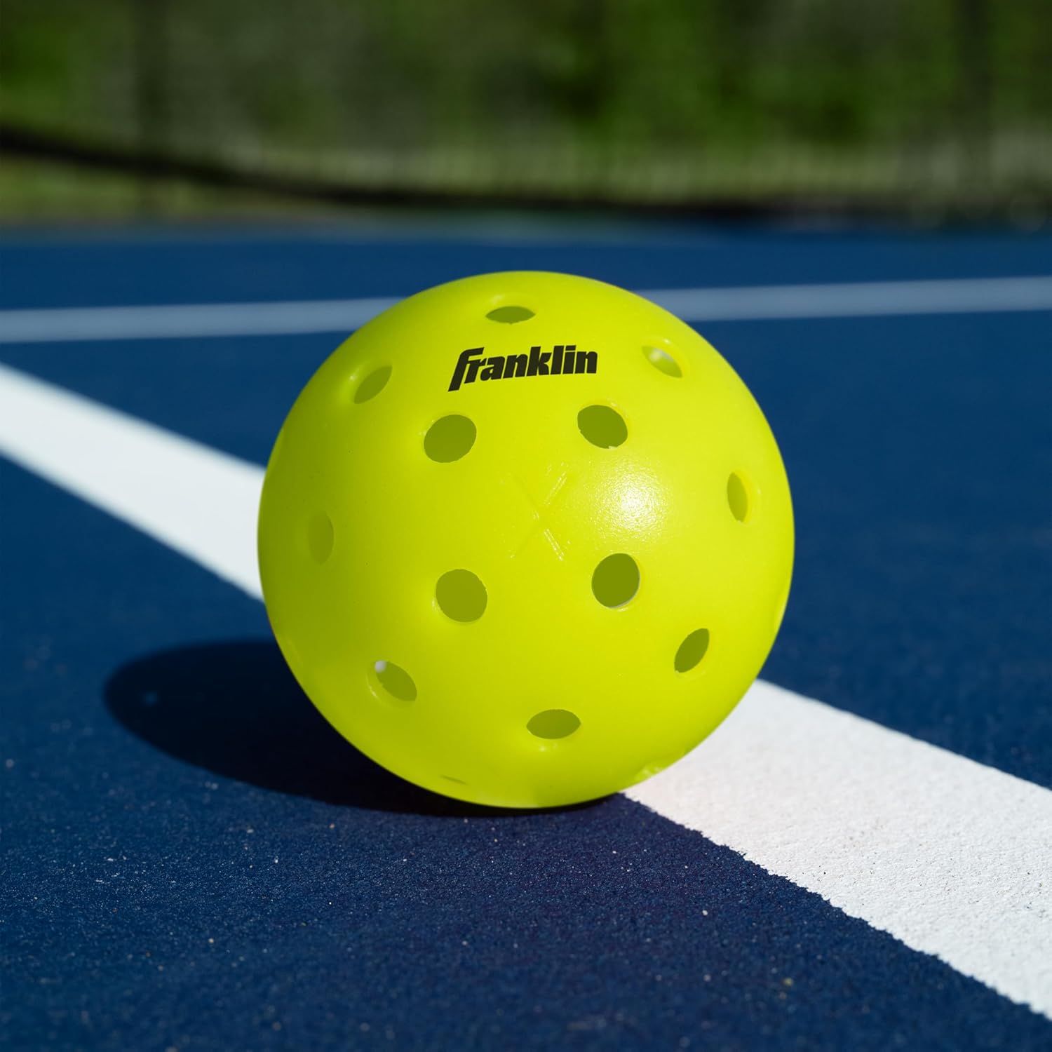 Shows the Franklin pickleball in its real-world environment on a court, helping shoppers visualize the product in actual play conditions.