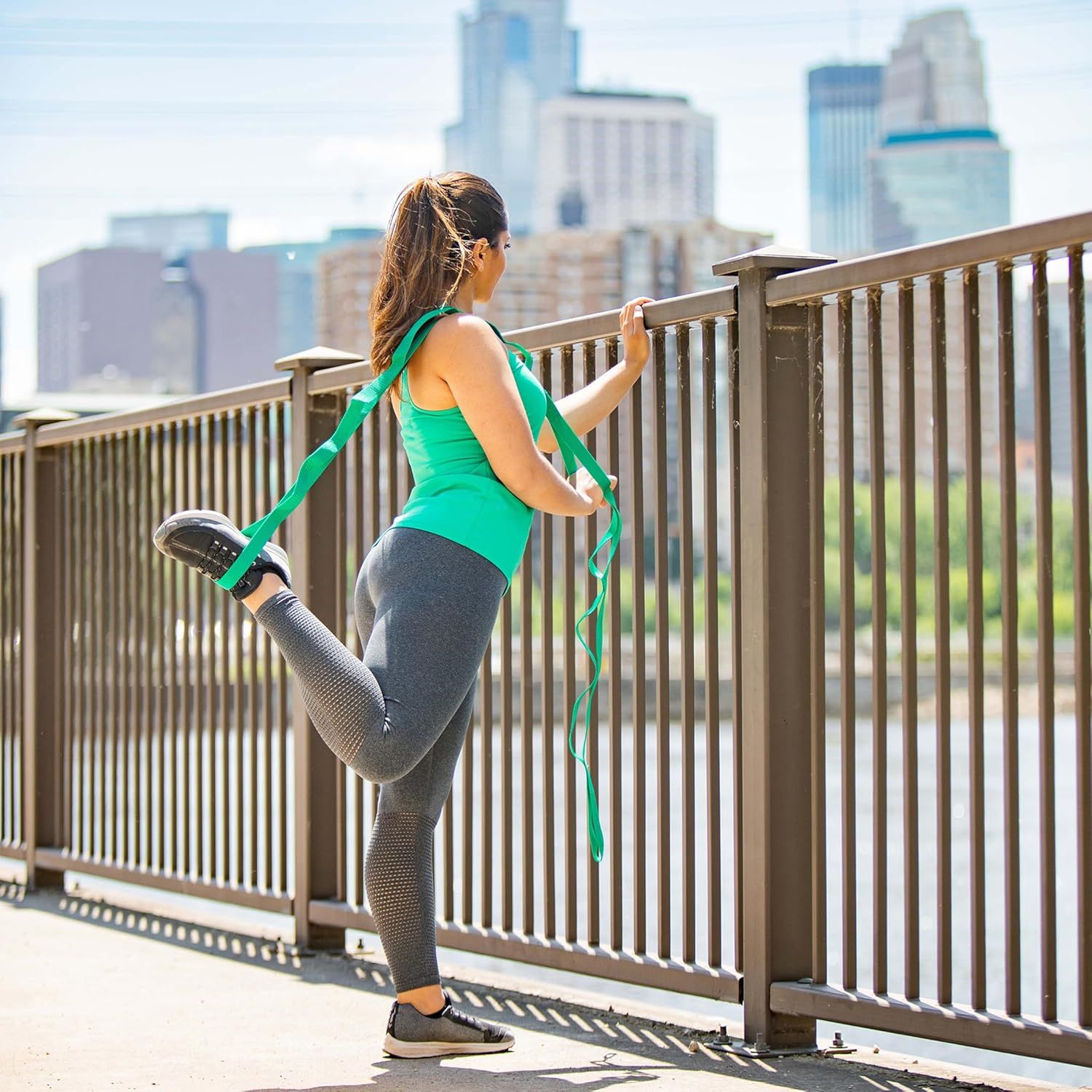 Demonstrates the product (resistance band) in a real-world fitness context to help shoppers visualize using it during outdoor workouts and stretching routines.