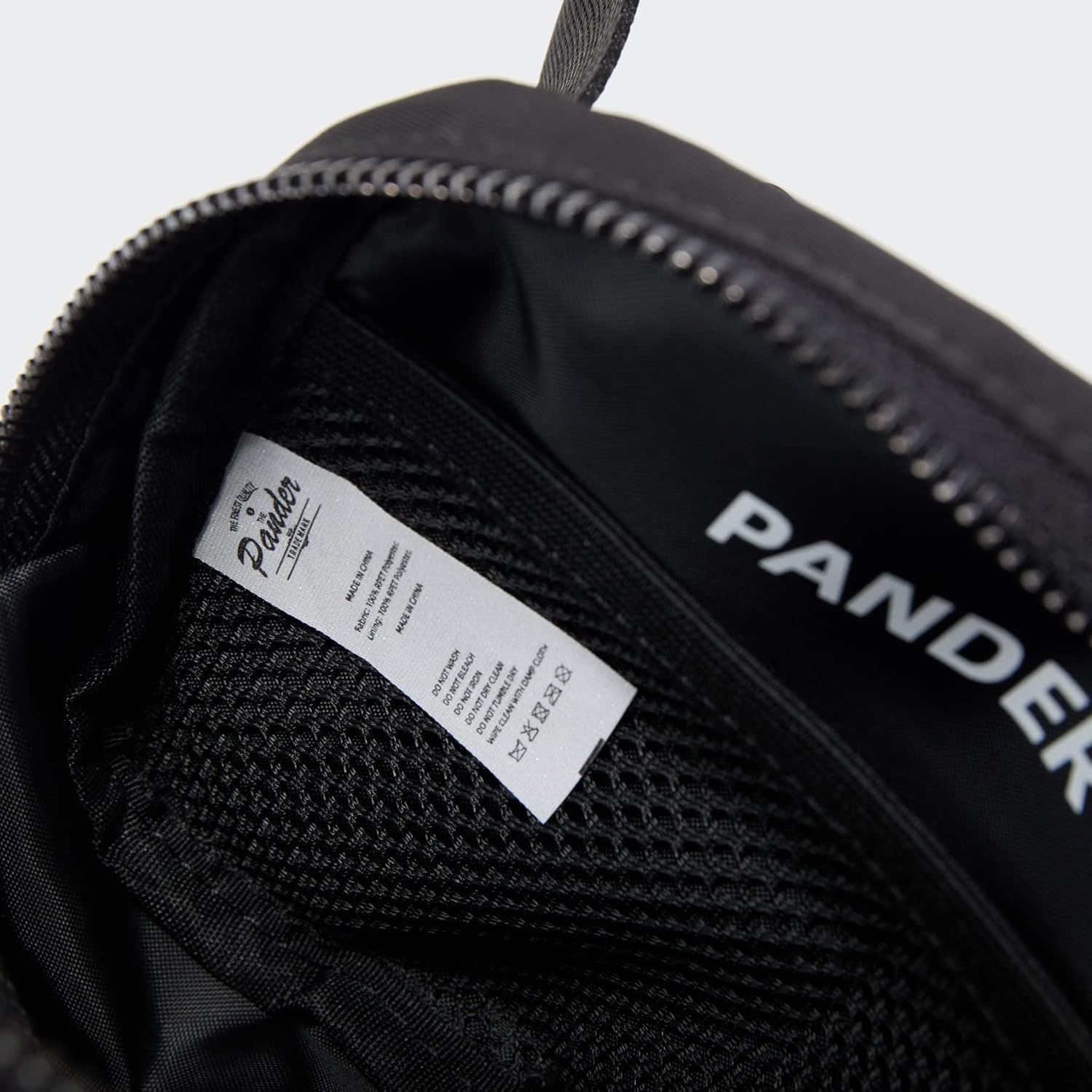 Shows the interior construction and branding details of the product, highlighting the quality label and zipper mechanism to communicate craftsmanship and authenticity.