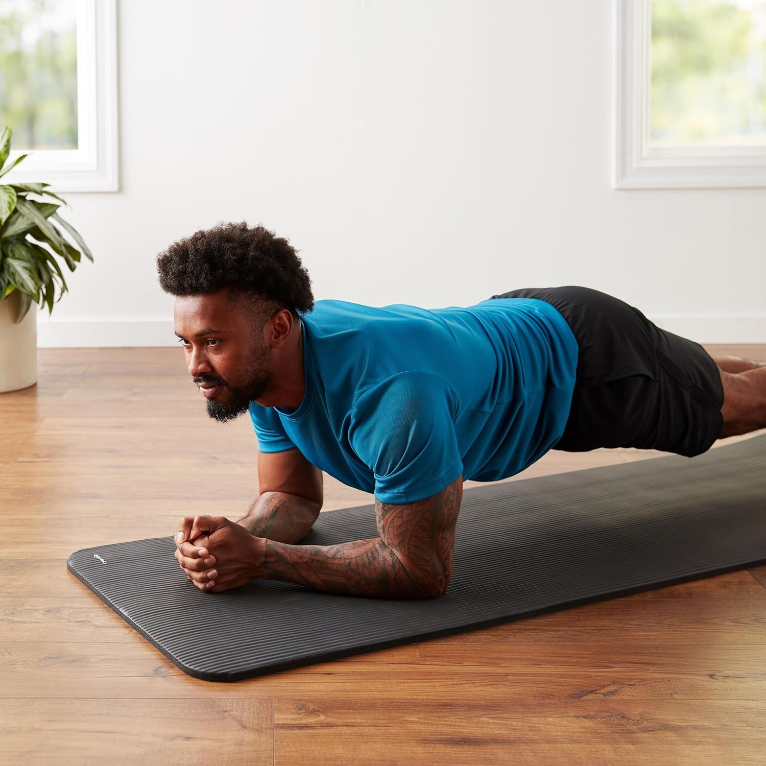 Demonstrates the product being used in a real-world home fitness setting to help shoppers visualize how the mat fits into their workout routine.
