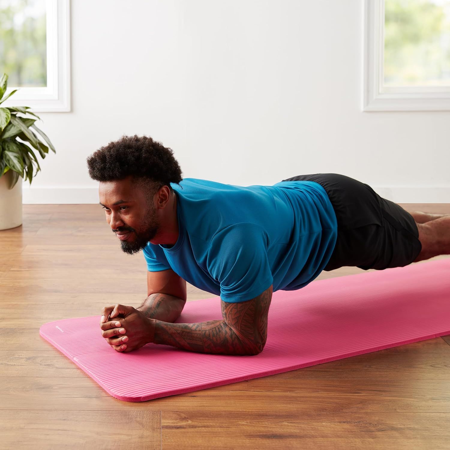 Demonstrates the product in a real-world home fitness context to help shoppers visualize using the yoga mat for their own workouts.