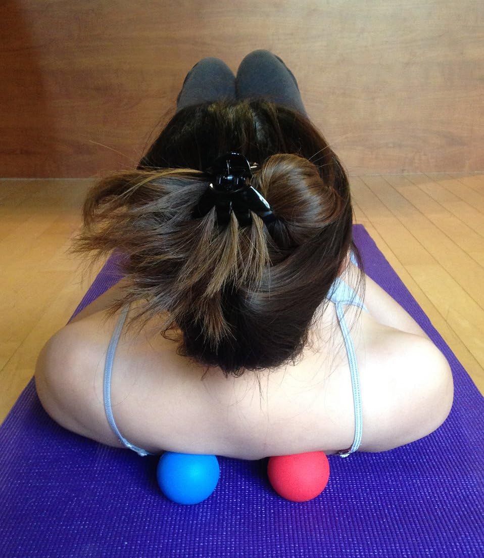 Demonstrates how to use the massage balls for upper back and shoulder tension relief, showing proper positioning on a yoga mat. Shows the product being used in a real-world home exercise environment…