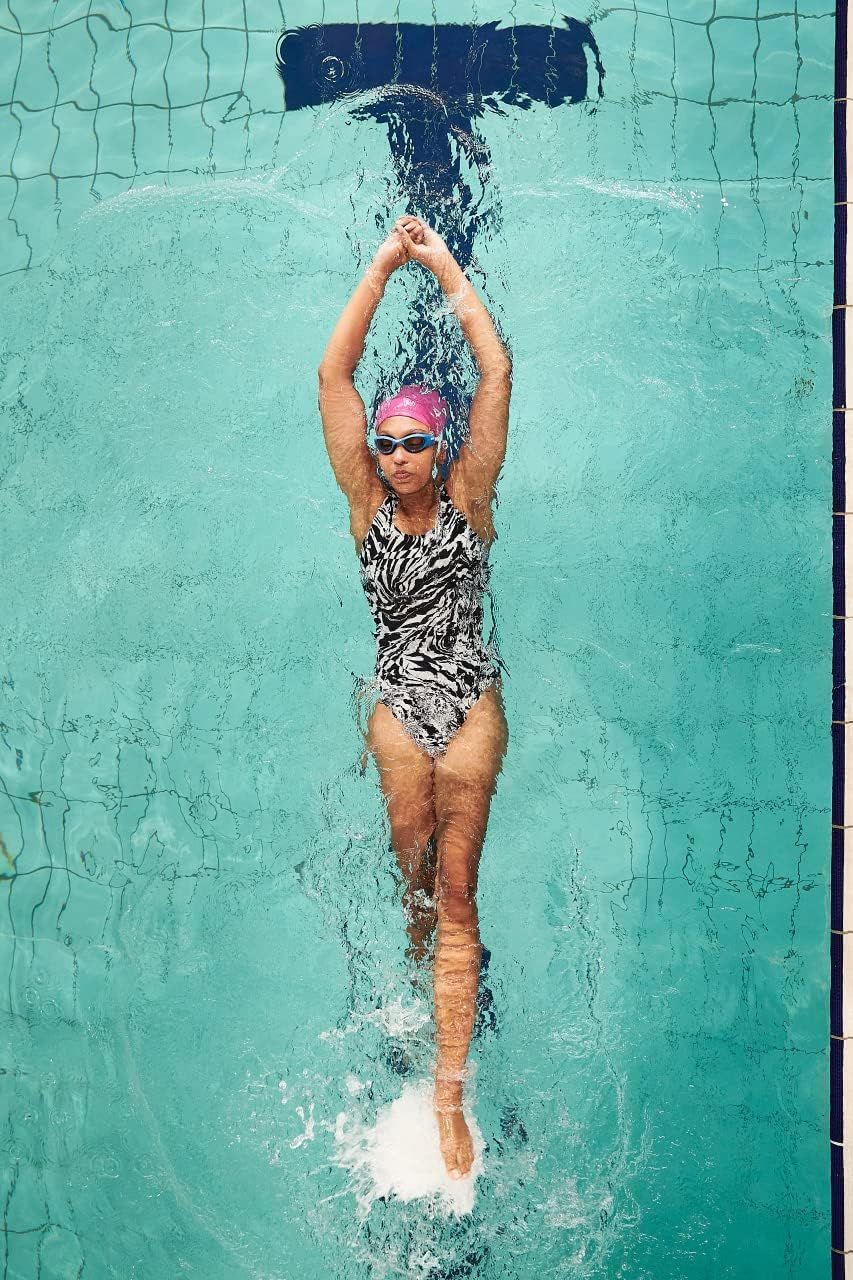 Demonstrates the product in a real-world swimming context to help shoppers visualize themselves using the swimwear during active pool activities.