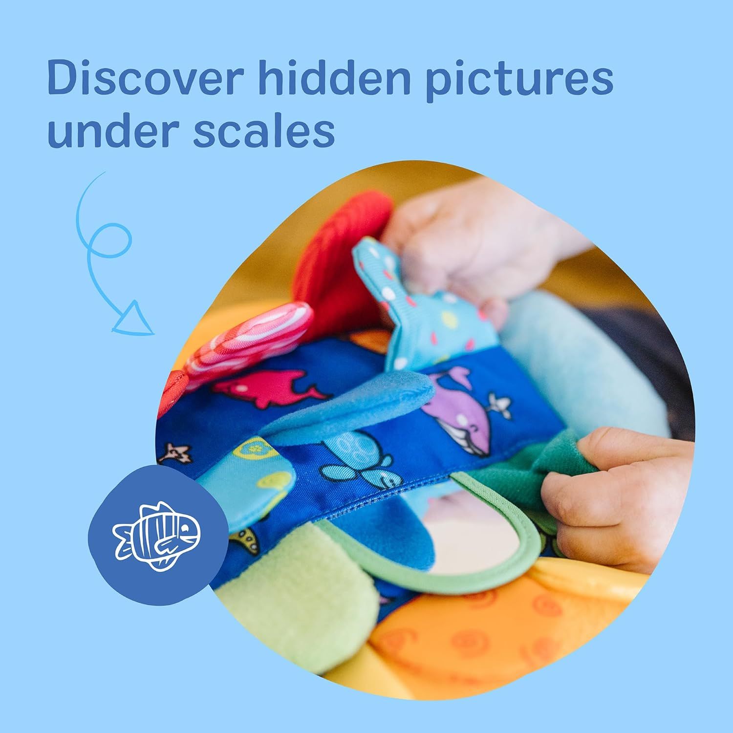 Highlights the toy's interactive feature that allows children to discover hidden pictures under scales, promoting sensory exploration and engagement.