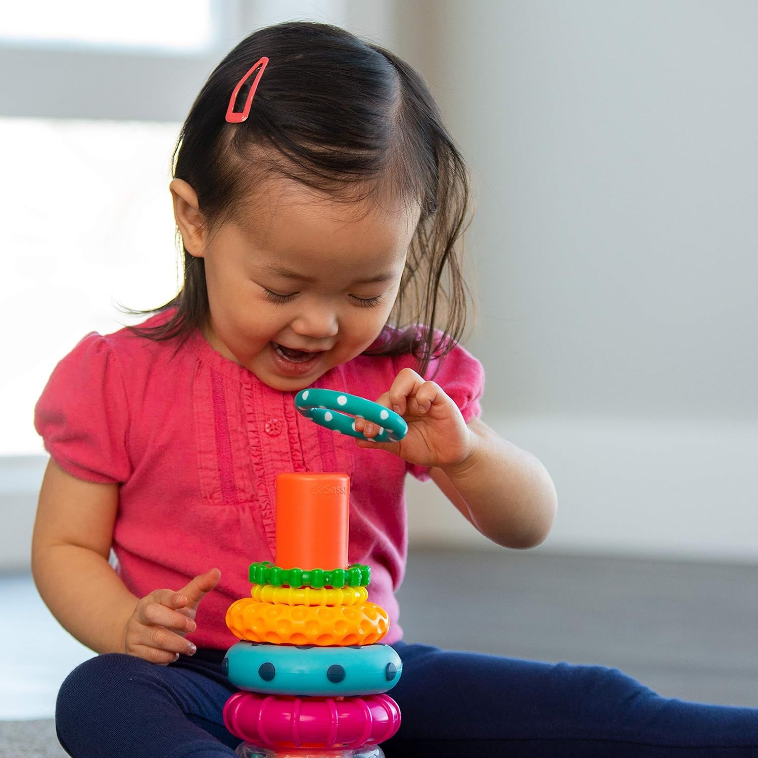 Demonstrates the product in use by a young child in a real-world home setting, showing engagement and developmental play to help parents visualize the product's appeal and age-appropriateness.