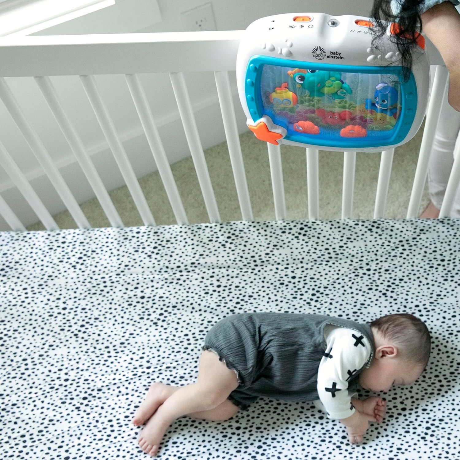 Shows the product in a real-world nursery setting with a baby sleeping in the crib, demonstrating how the product naturally fits into everyday use and reassuring parents about its practical…