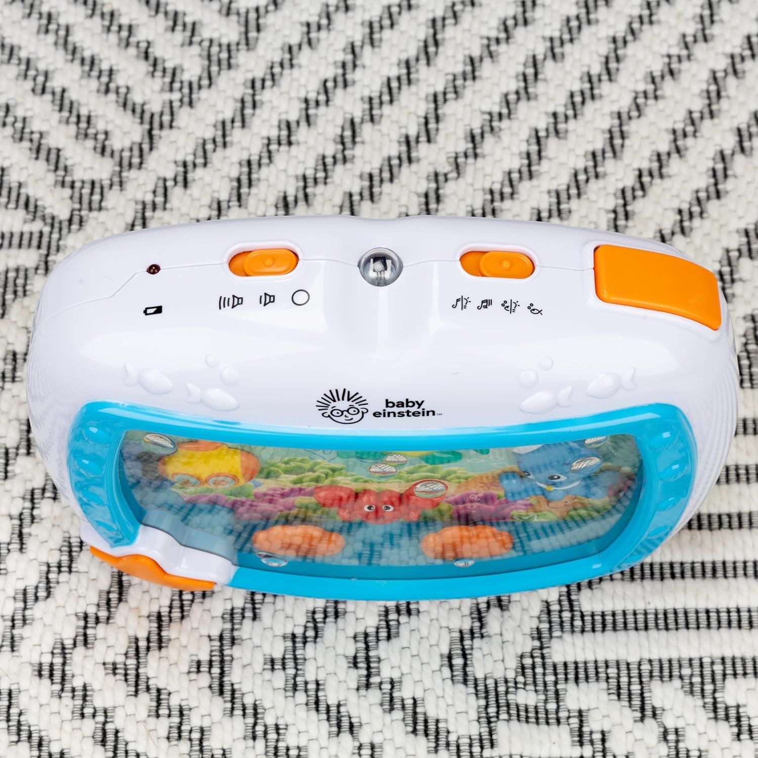 Displays the Baby Einstein toy clearly on a neutral background to show the product design, buttons, and underwater scene display without distractions.