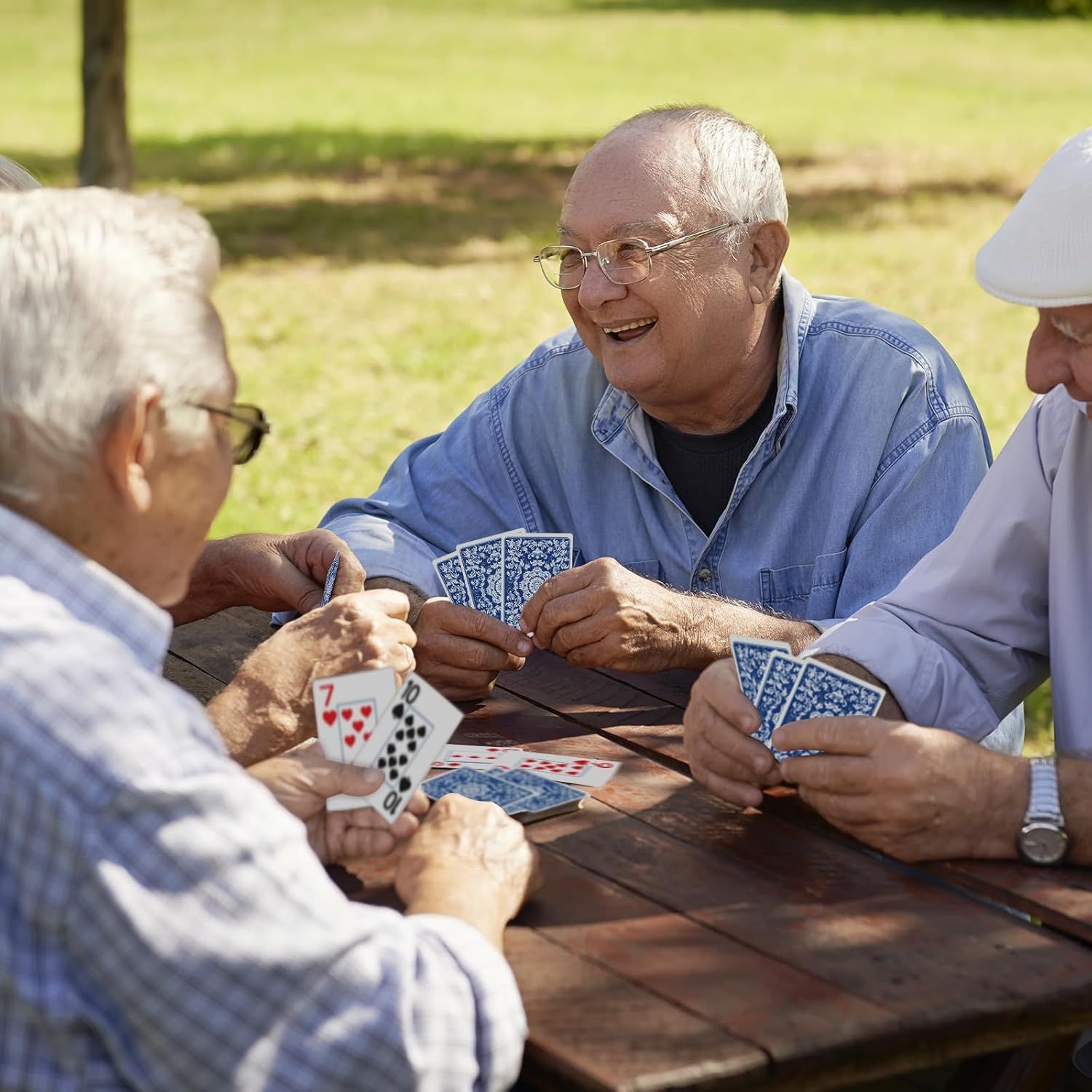 Shows the product (playing cards) being used in a real-world social setting to help shoppers visualize the product in their own lives and understand its use case for leisure and social connection.