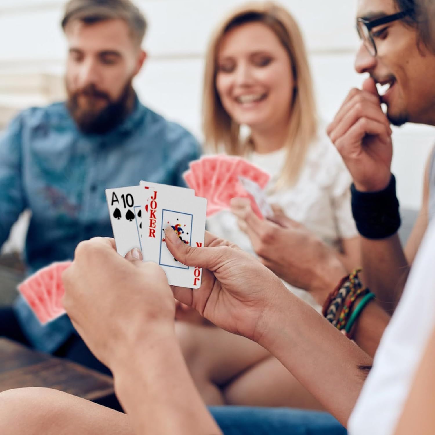 Shows the product (playing cards) being used in a real-world social setting to demonstrate its role in bringing people together for entertainment and fun.