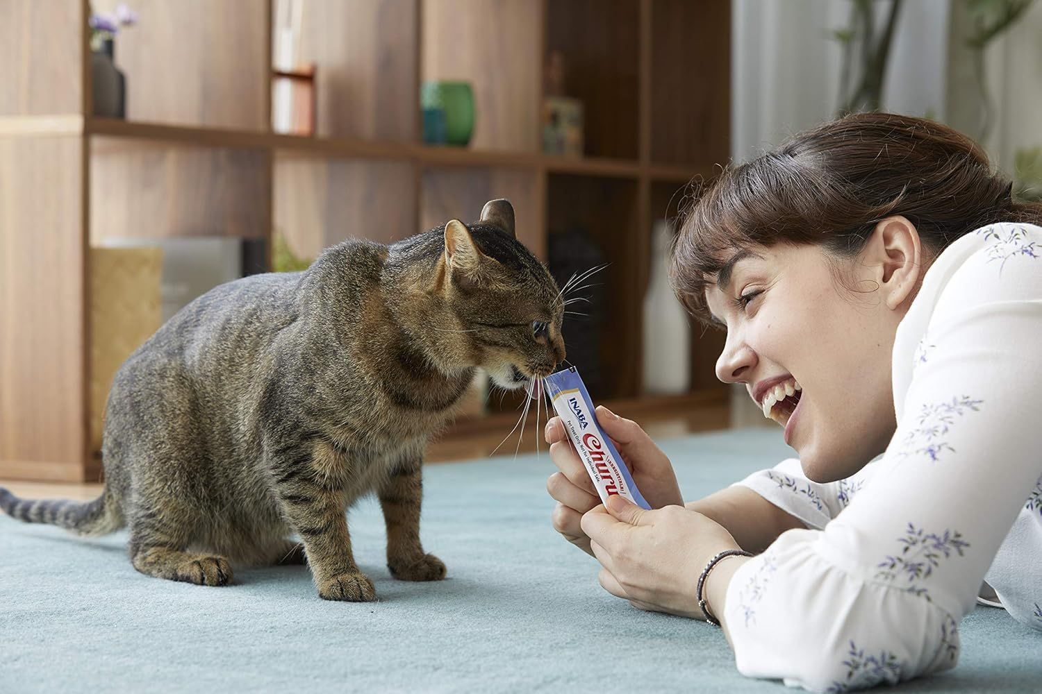 Shows the product being used in a real-world home setting with a cat, creating an emotional connection and demonstrating natural product interaction.