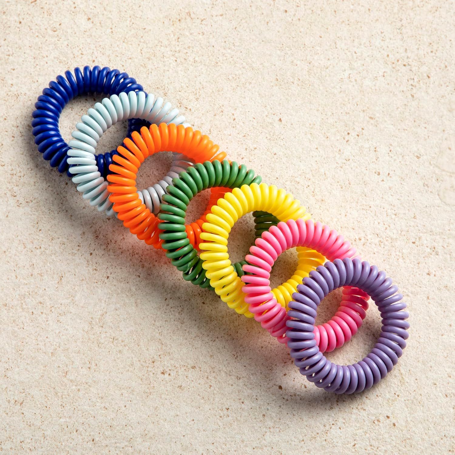 Showcases the brand's product lineup by displaying multiple color options available for the coil hair ties, helping shoppers understand the variety and choose their preferred style.