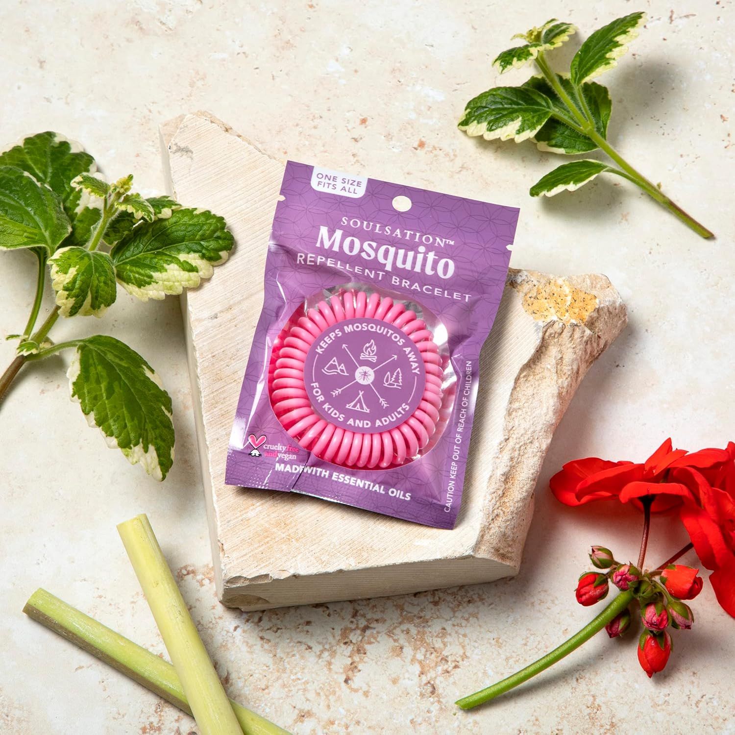 Presents the mosquito repellent bracelet in an aesthetically pleasing, natural lifestyle context with botanical elements to create an organic, appealing brand image.