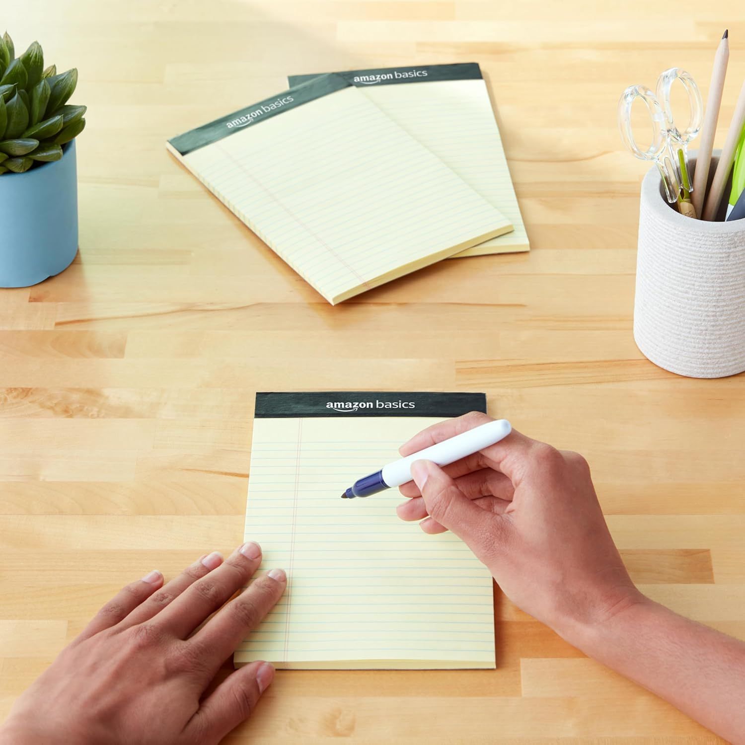 Shows the product in a natural, everyday setting to help shoppers visualize how the notepads fit into their workspace or daily routine.