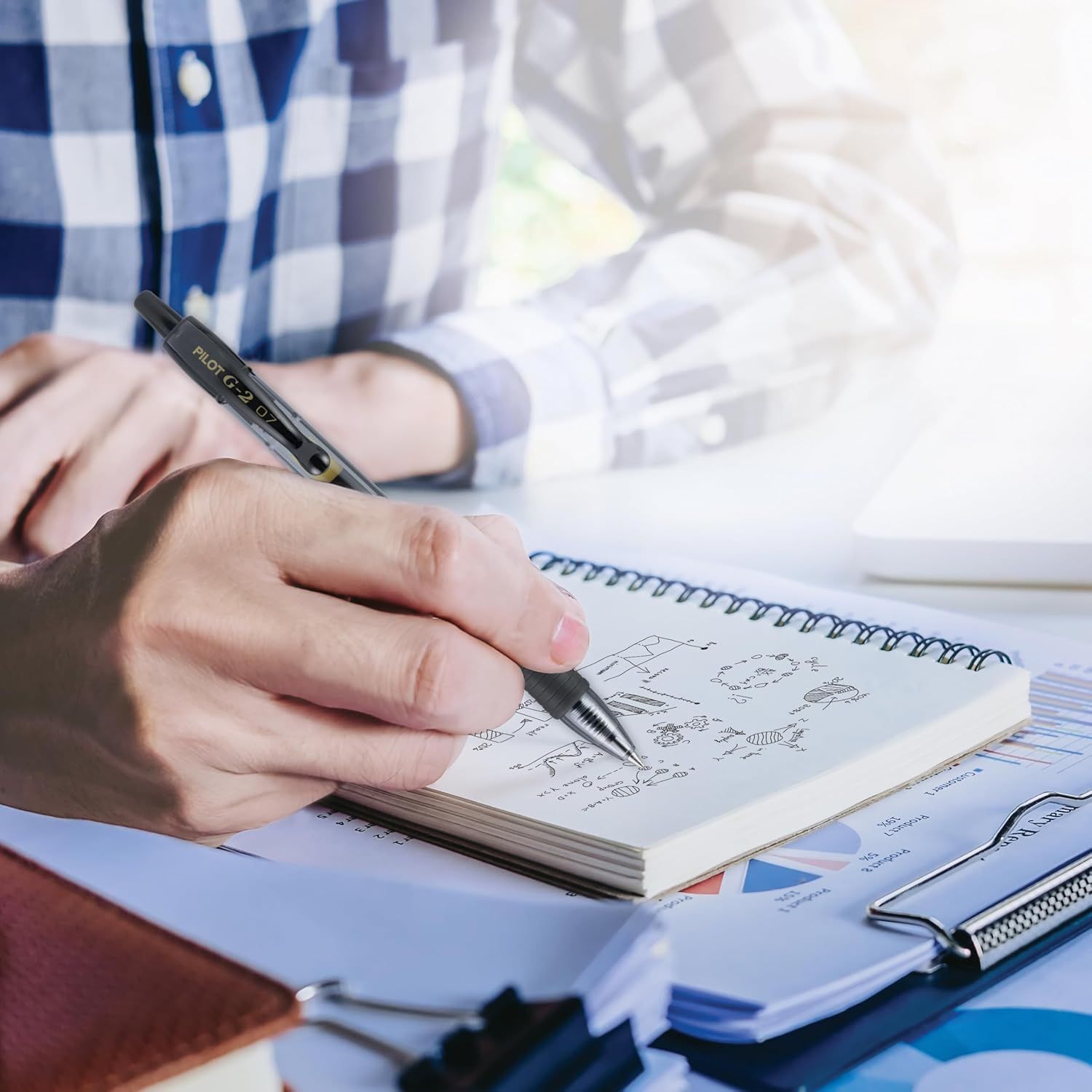Demonstrates the product (pen) in a real-world professional context, showing it being used for note-taking and business work to help shoppers visualize everyday usage.