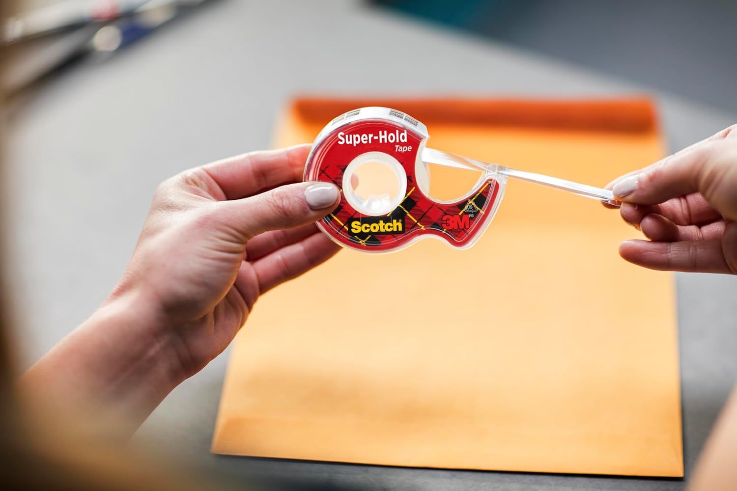 Shows the product being used in a real-world setting to help shoppers visualize how they would use the tape dispenser in their own daily tasks.