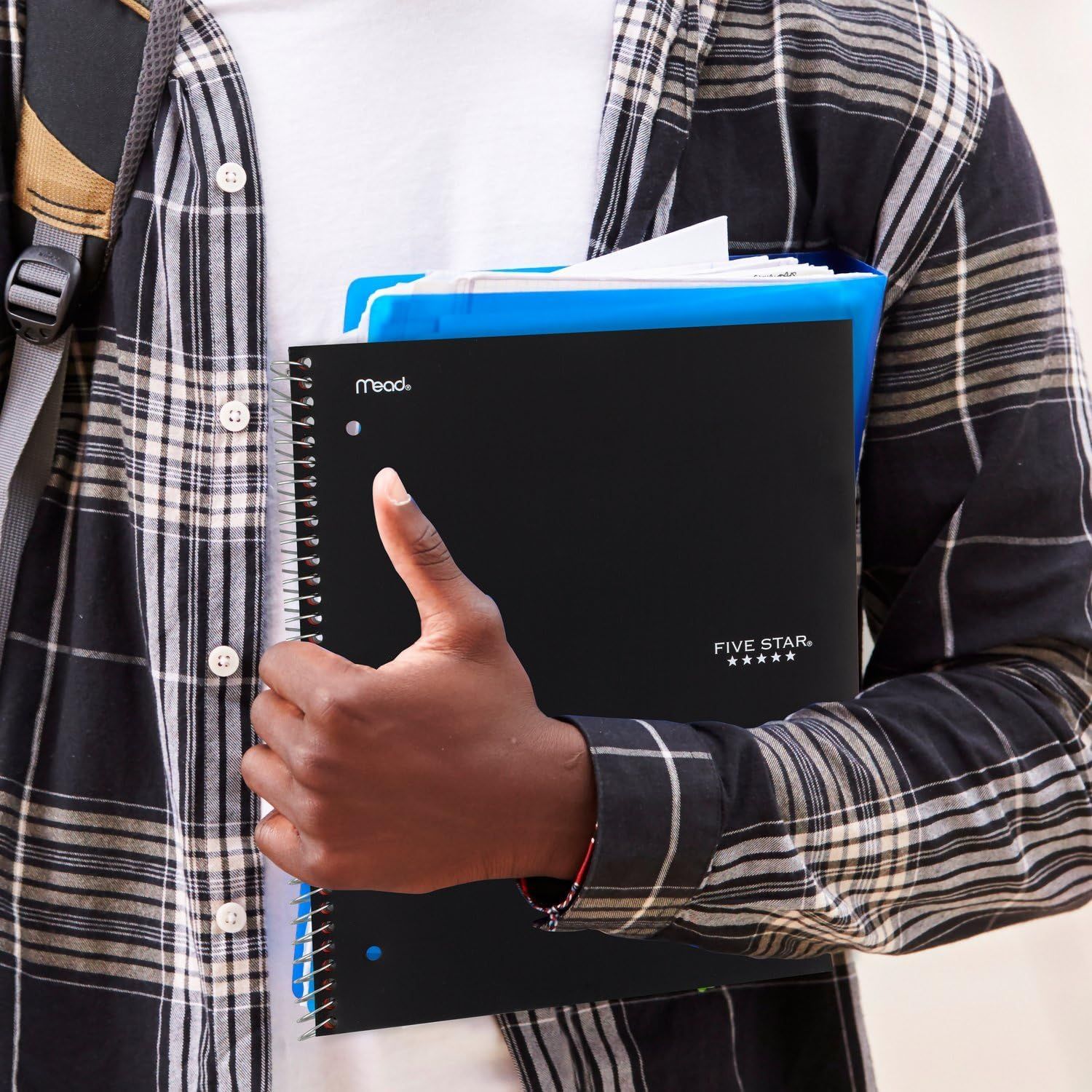 Demonstrates the product in an authentic, everyday setting to help shoppers visualize how they would use the notebooks in their own life, particularly in school or work environments.