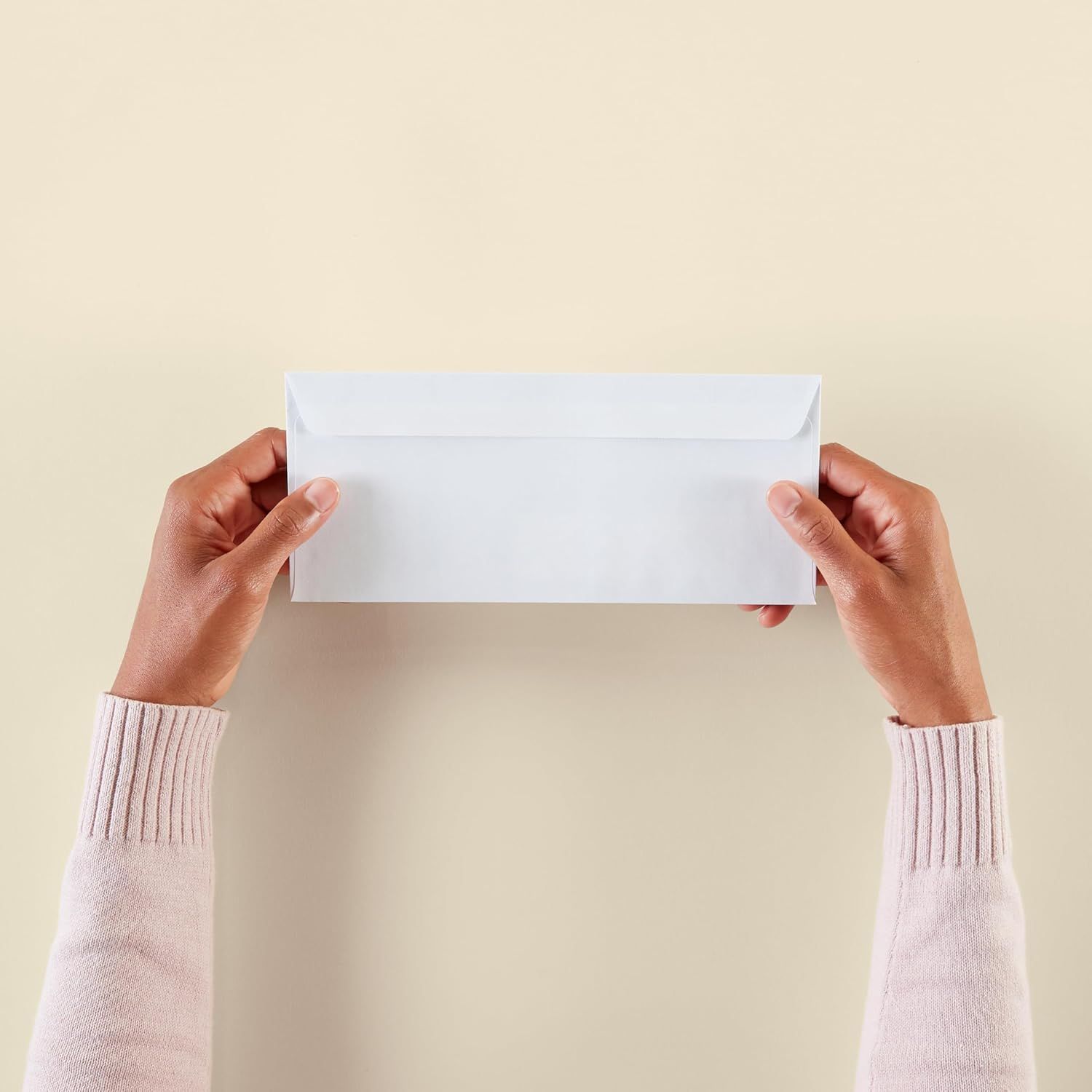 Shows the product (envelope) in a natural, real-world context being held by hands to help shoppers visualize the product in use.