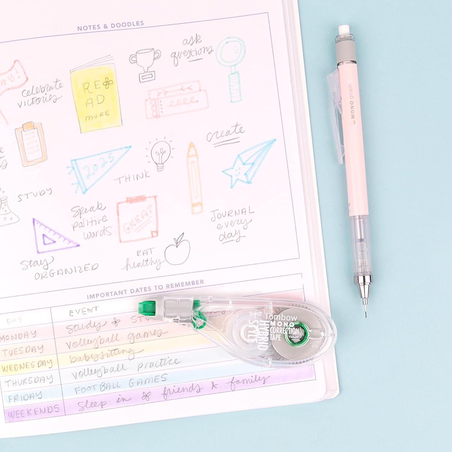 Displays the product (planner and pen/correction tape) in a clean, lifestyle setting to show what the customer receives and how it looks in use.