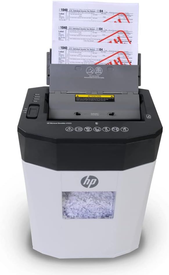 Demonstrates the product in a real-world usage scenario, showing the shredder actively processing tax documents to help shoppers visualize how it works in their environment.