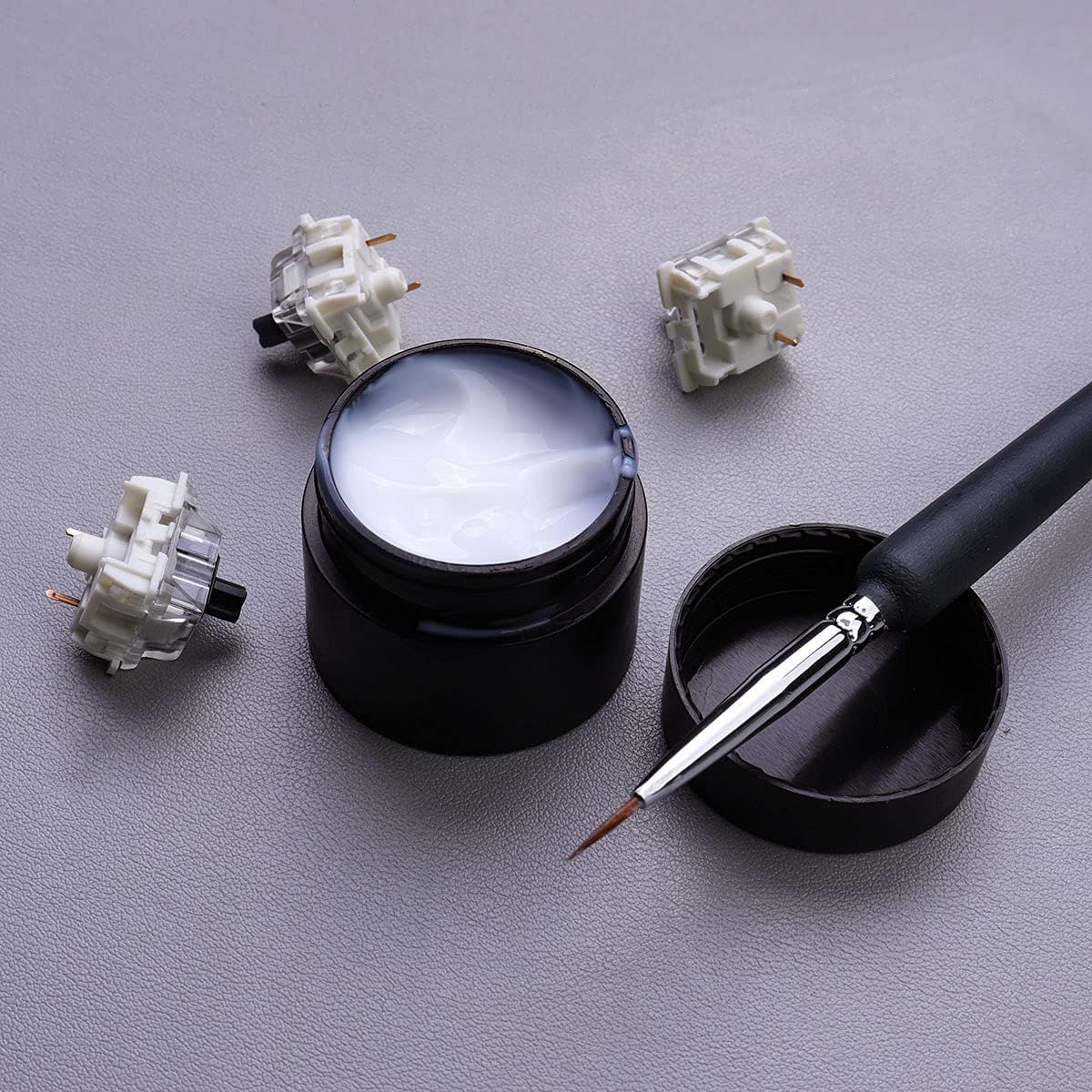Shows all components included with the product, including mechanical switches, lubricant container, and precision brush tool, to help shoppers understand the complete value of what they receive.